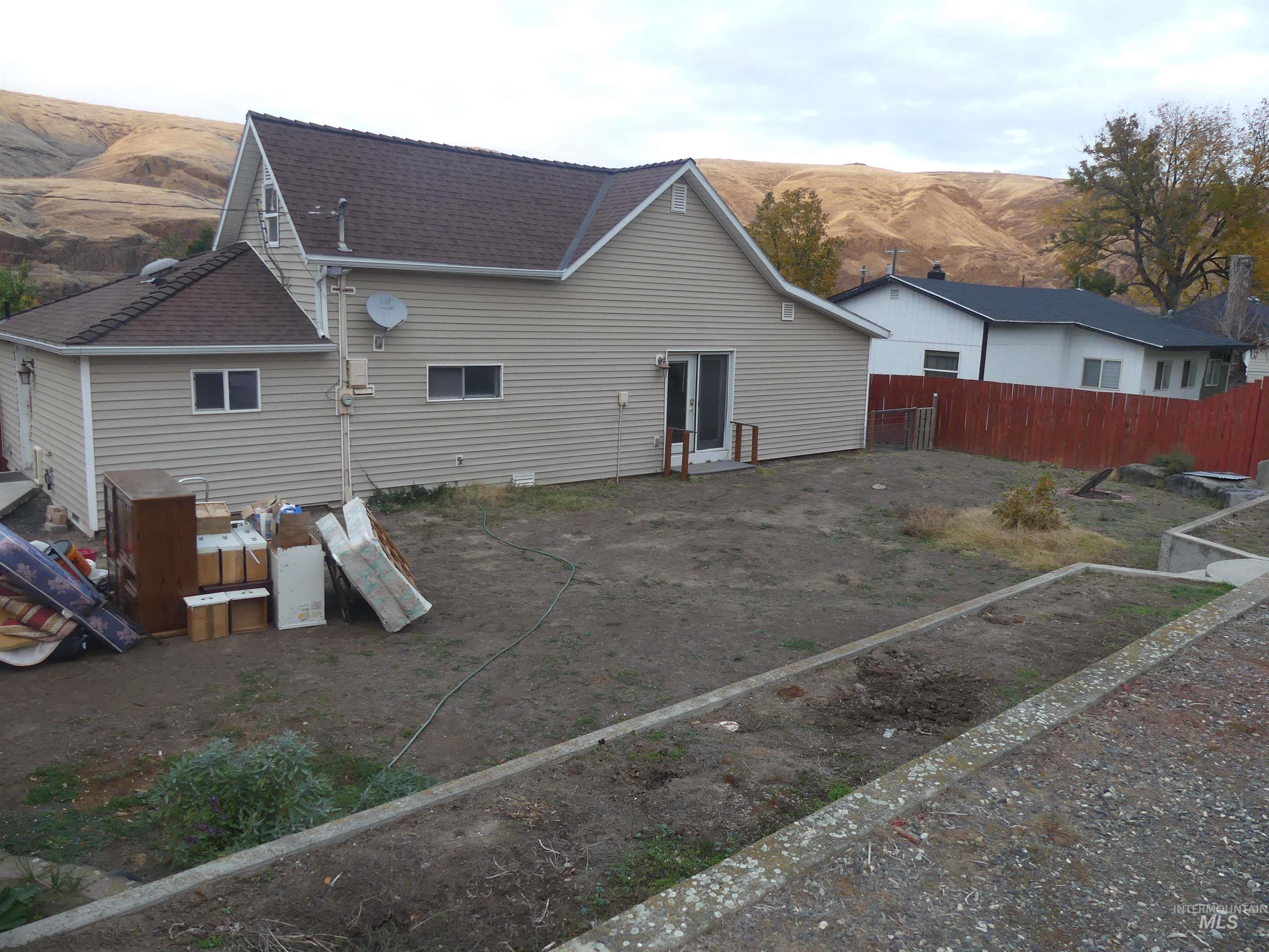 Rear view of property featuring a mountain view and roof with shingles