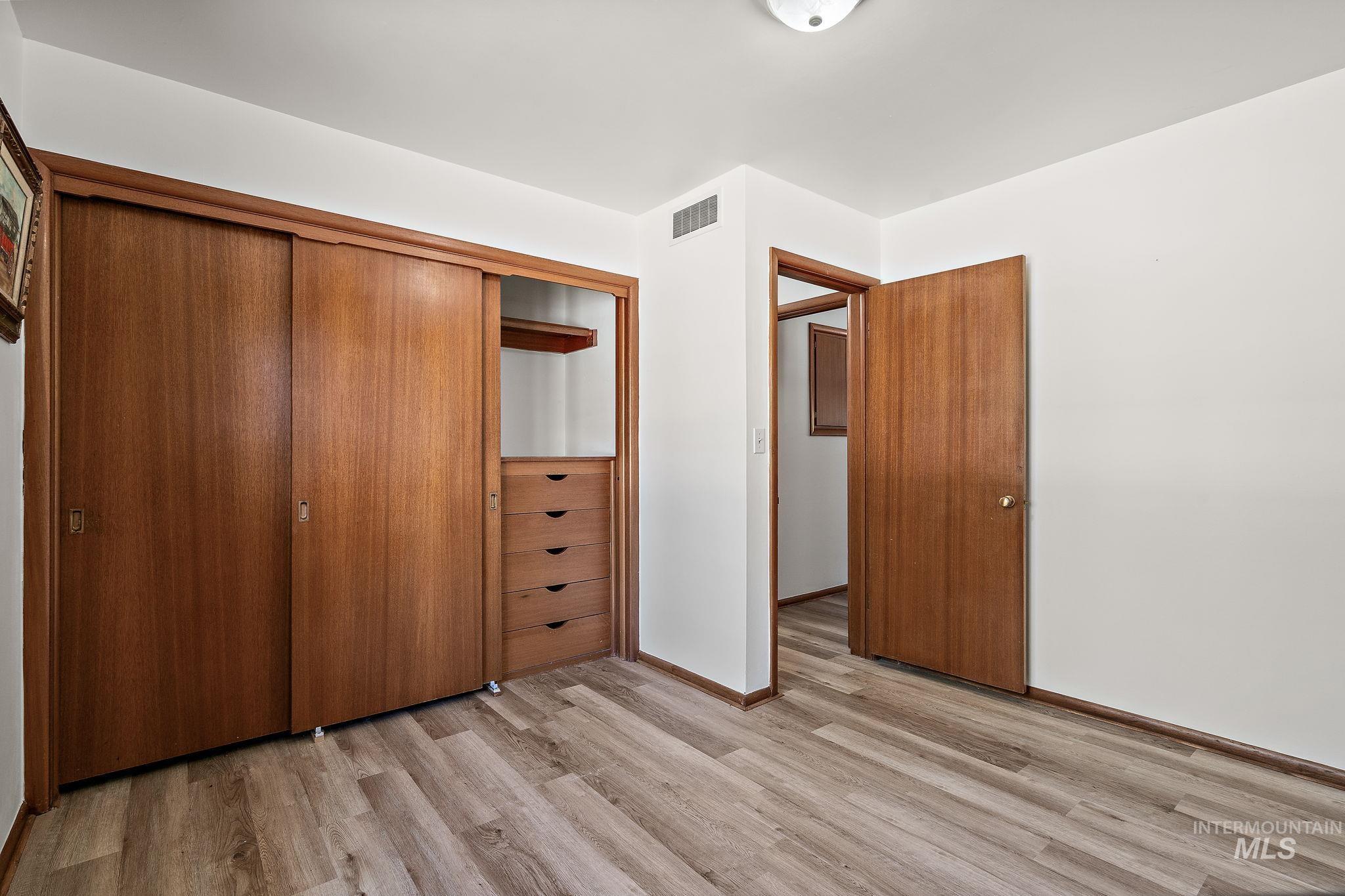 Unfurnished bedroom with light wood finished floors and a closet