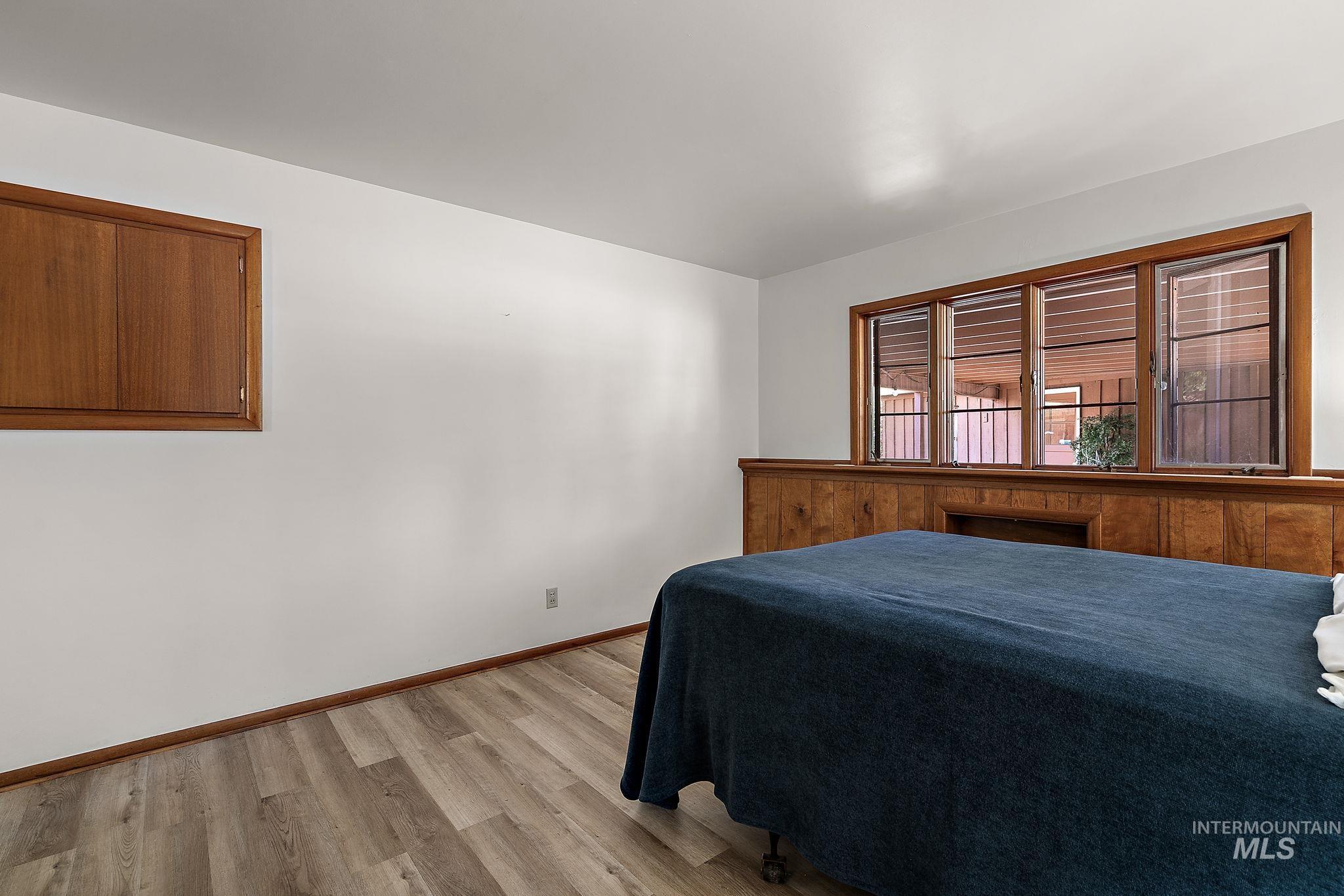 Bedroom with light wood finished floors and baseboards