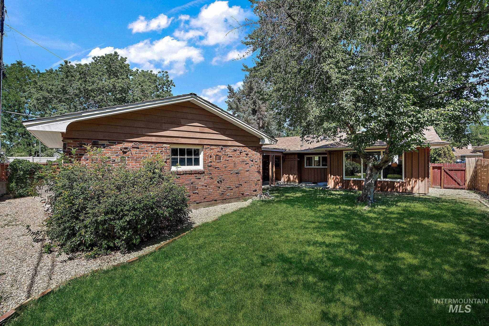 Back of property featuring brick siding, a gate, and board and batten siding