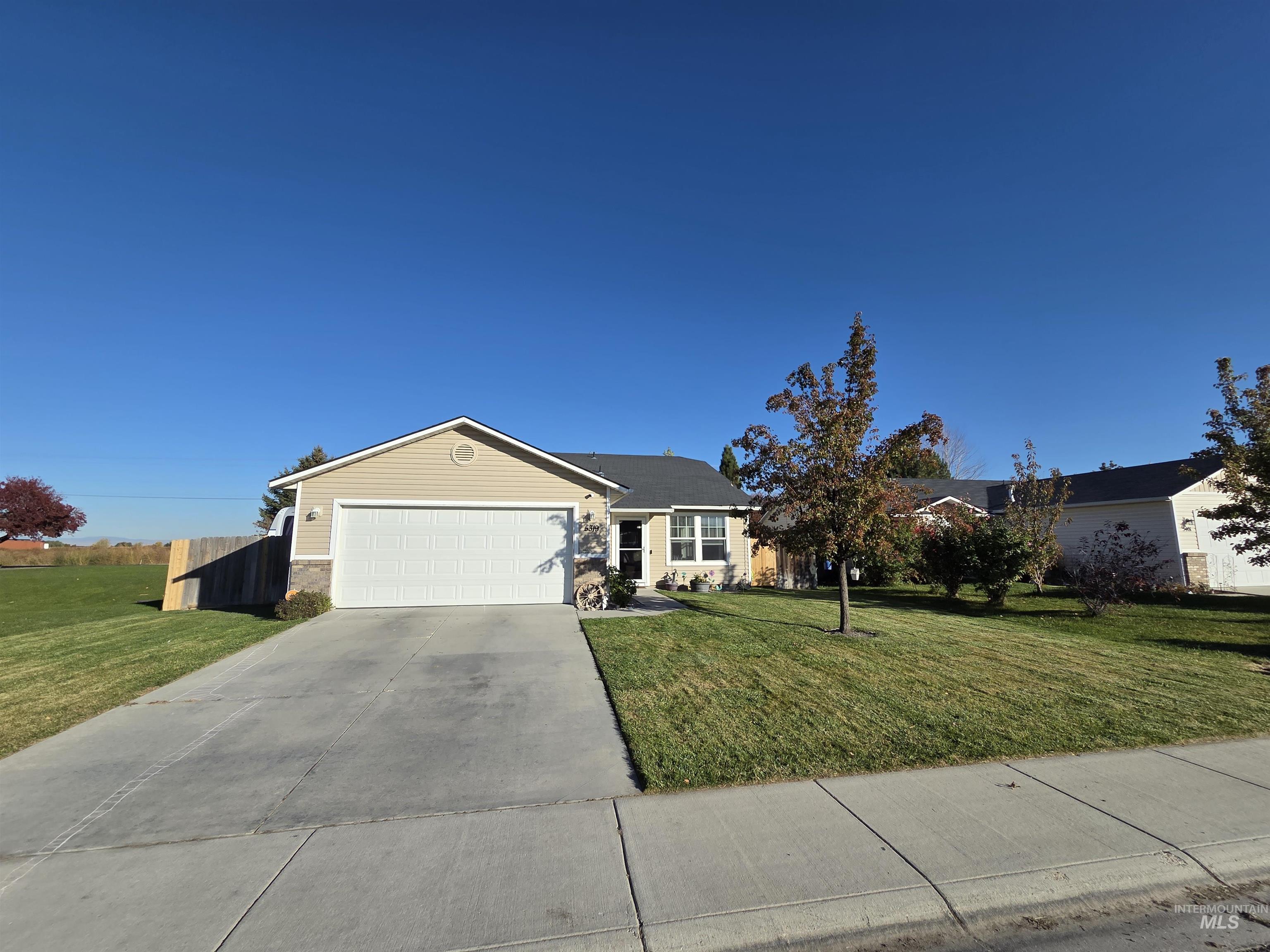 Single story home featuring concrete driveway and an attached garage