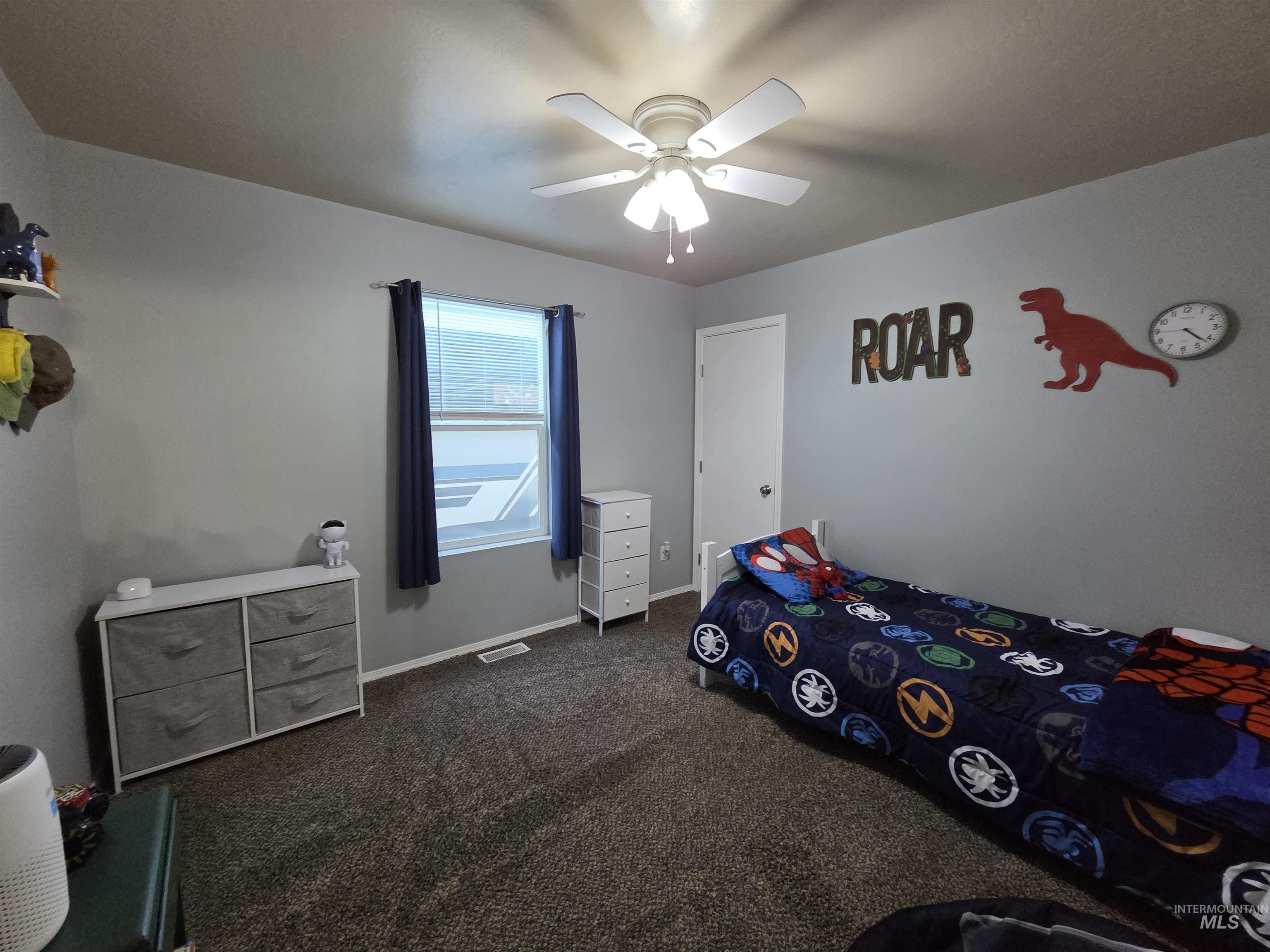 Bedroom featuring dark colored carpet and a ceiling fan