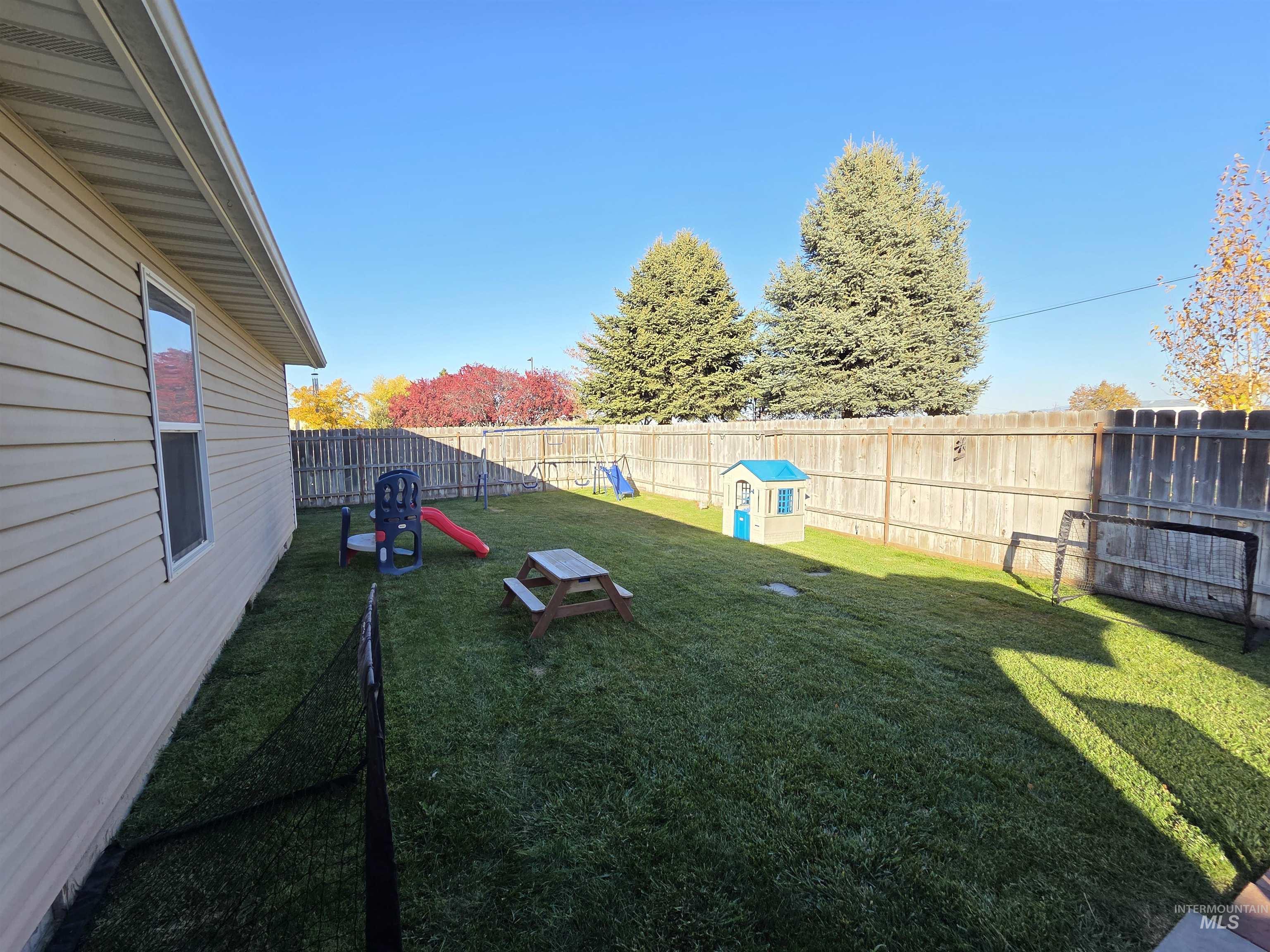 Fenced backyard with a playground