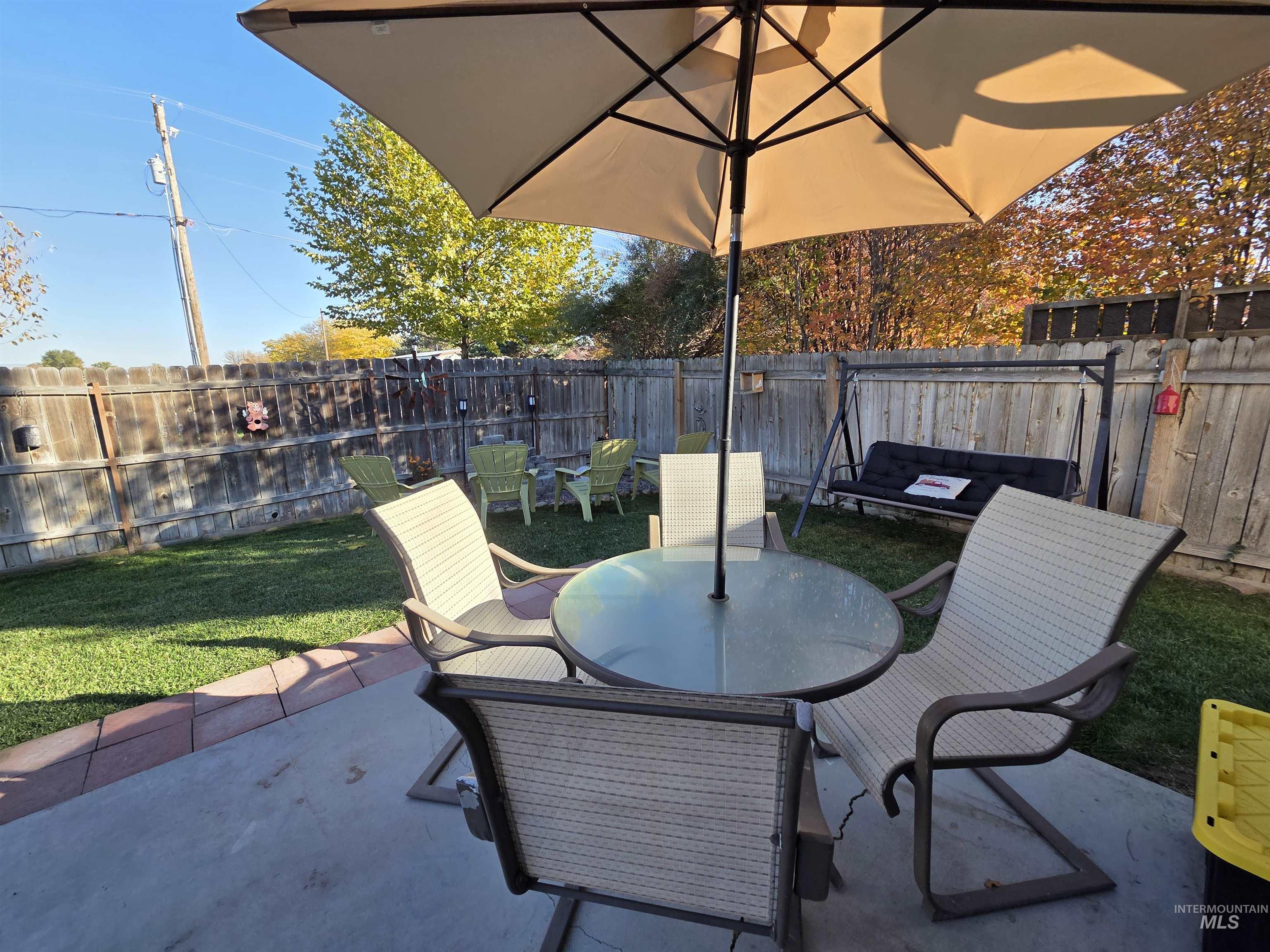 Fenced backyard with outdoor dining space and a patio area