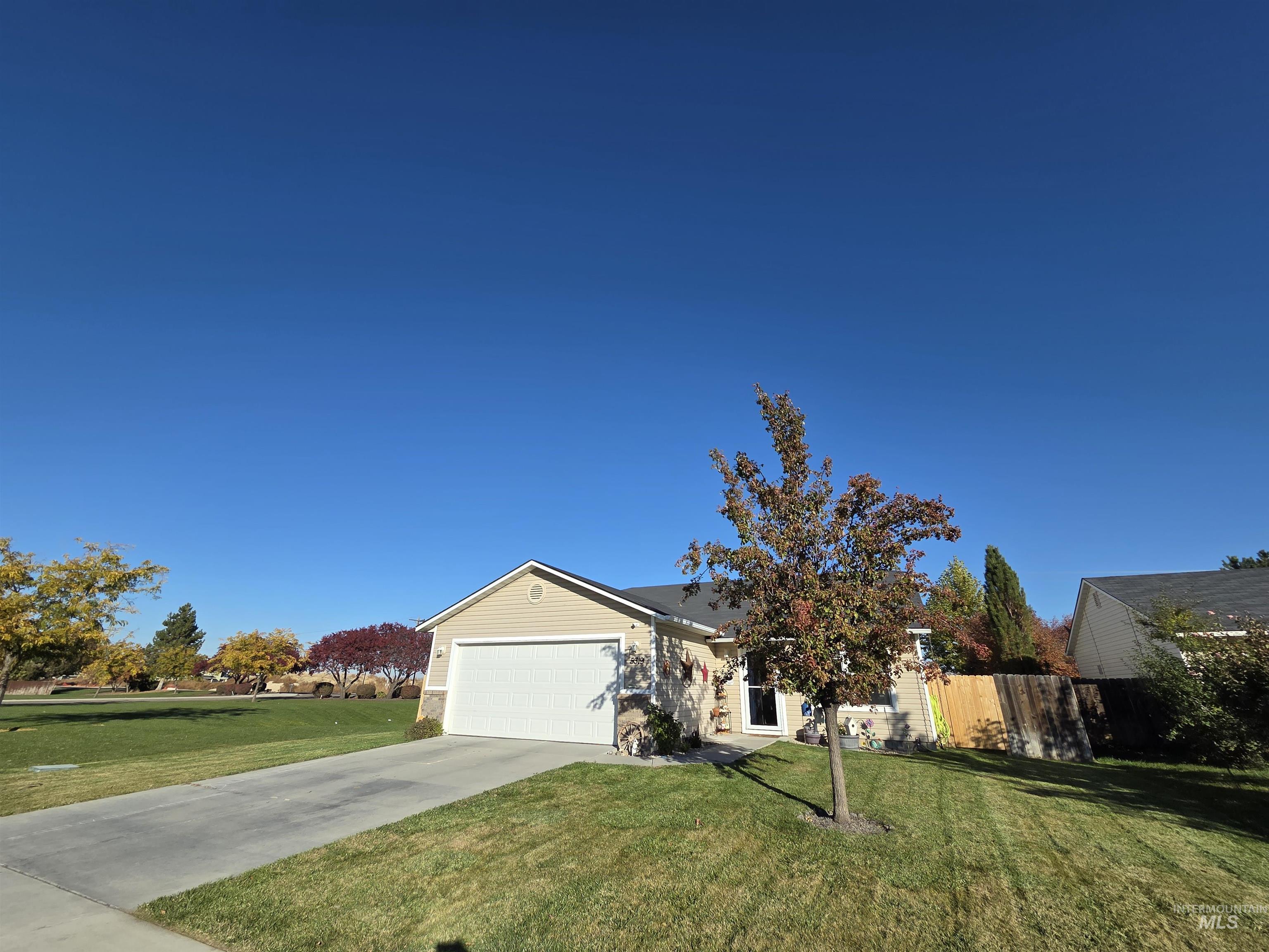 Ranch-style home featuring driveway and a garage