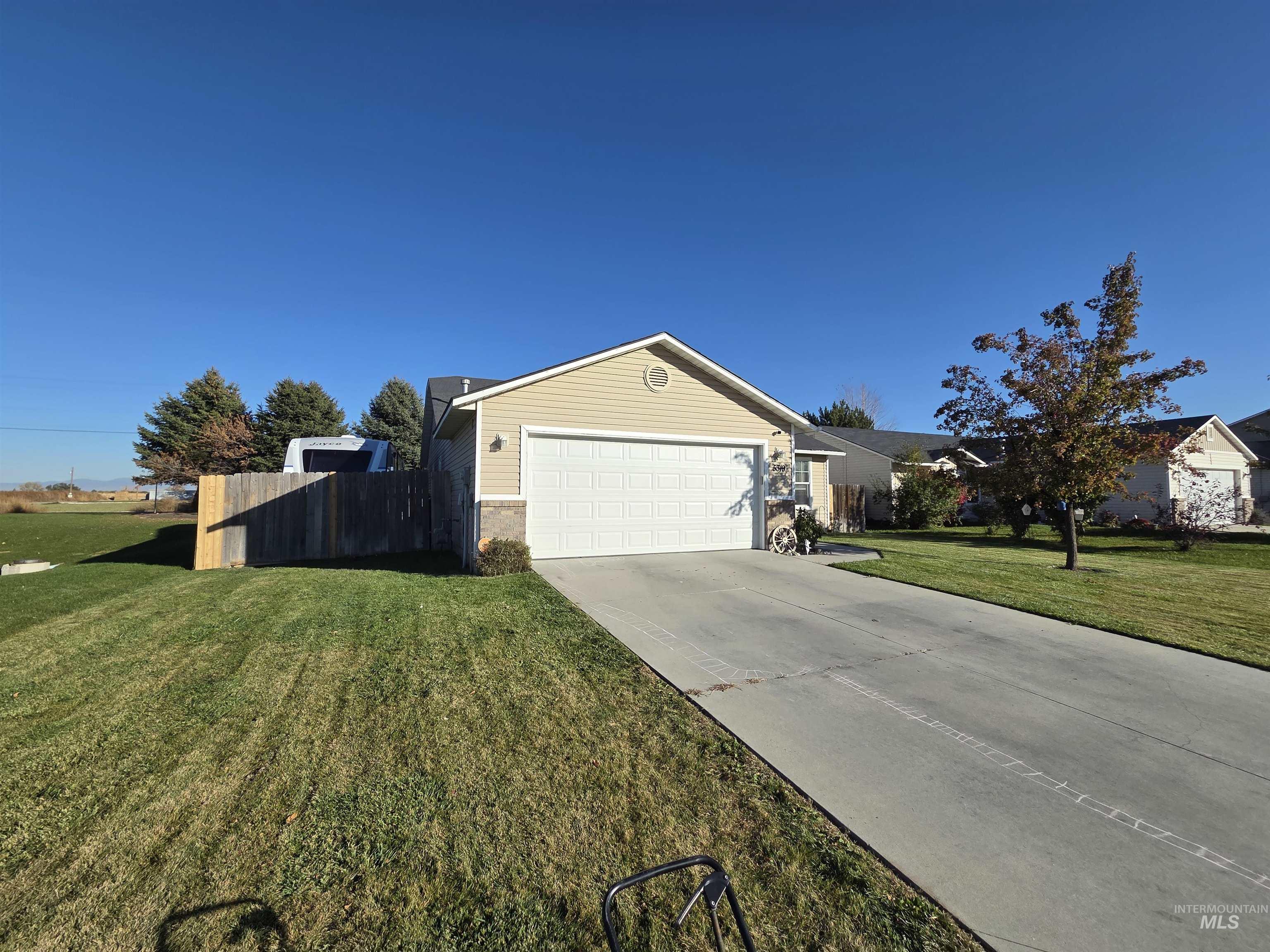 View of front of home with concrete driveway, an attached garage, and brick siding