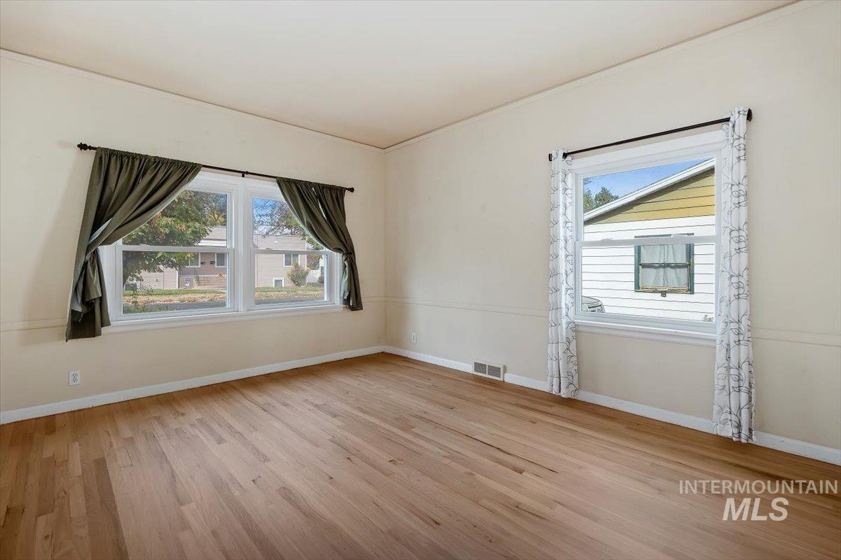 Spare room with light wood finished floors and ornamental molding