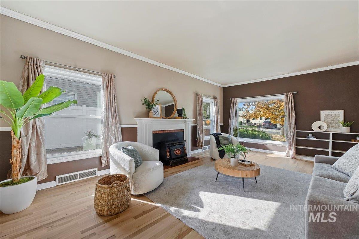 Living room with wood finished floors and ornamental molding