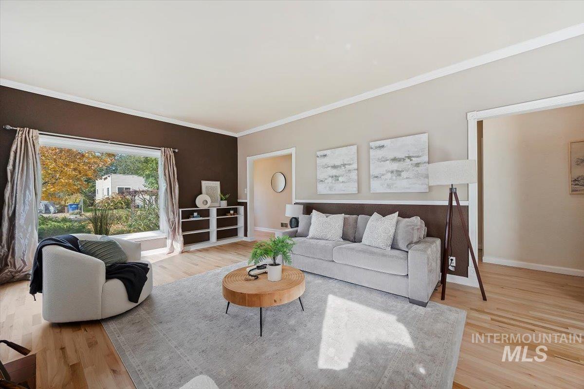 Living area featuring crown molding and light wood-style floors
