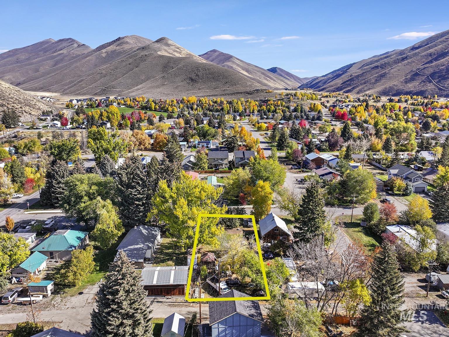 Aerial perspective of suburban area with a mountainous background and property parcel outlined