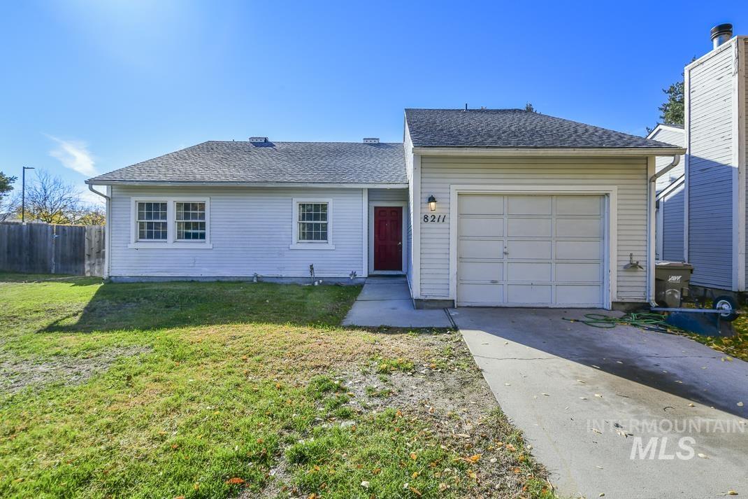 Ranch-style home featuring a garage, roof with shingles, and driveway