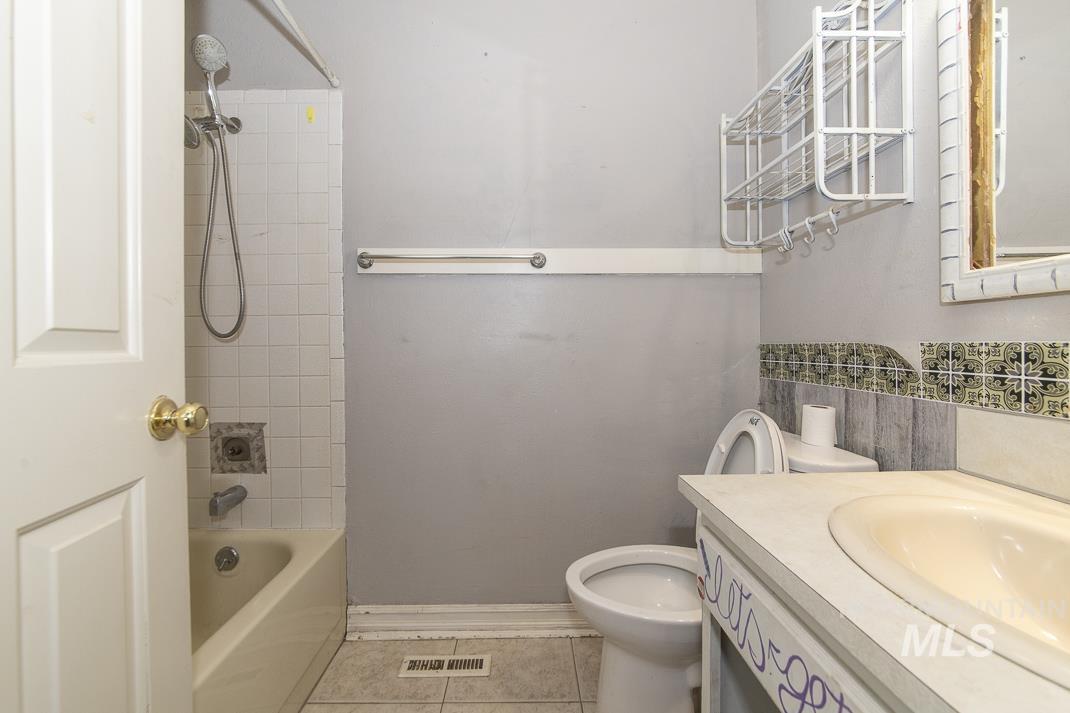 Full bath featuring vanity, shower / bath combination, and light tile patterned floors