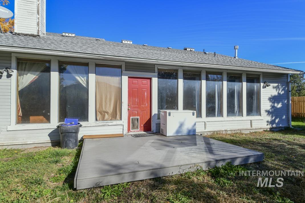 Rear view of property with a shingled roof, a chimney, and a lawn
