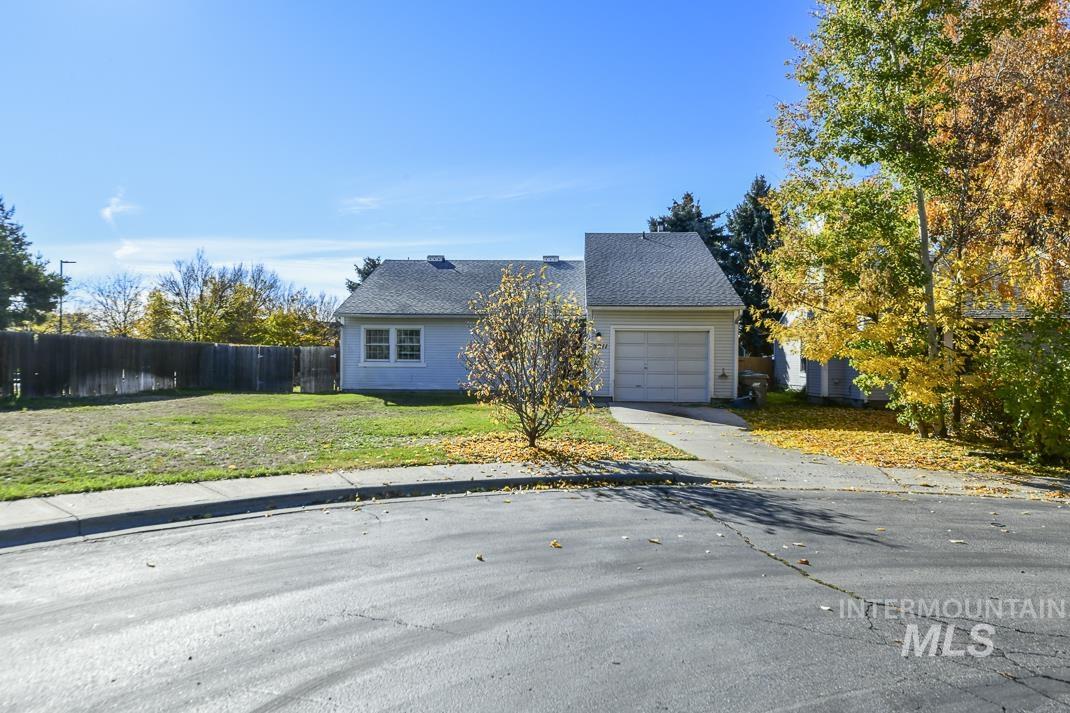 View of front of home featuring concrete driveway, roof with shingles, and an attached garage