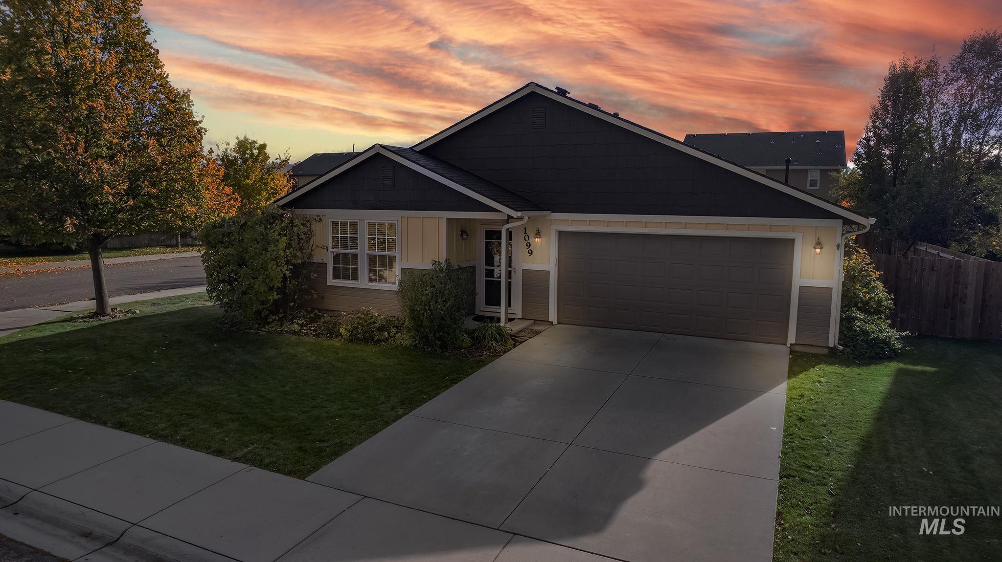View of front of property with board and batten siding, driveway, and a garage