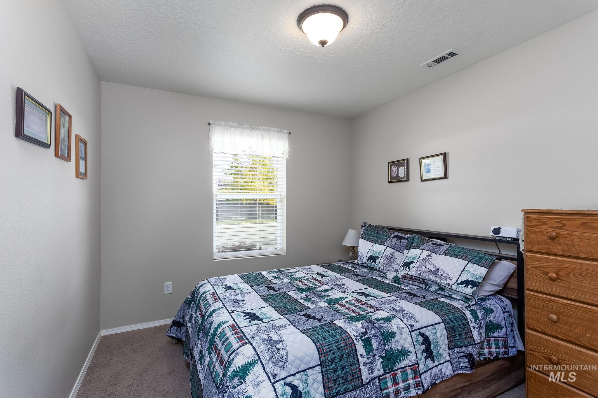 Bedroom with carpet floors and a textured ceiling