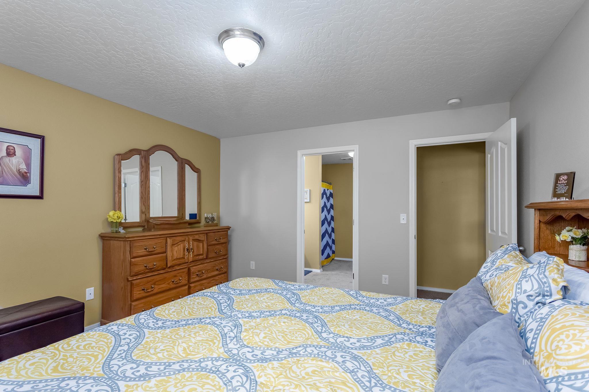 Bedroom with a textured ceiling and carpet
