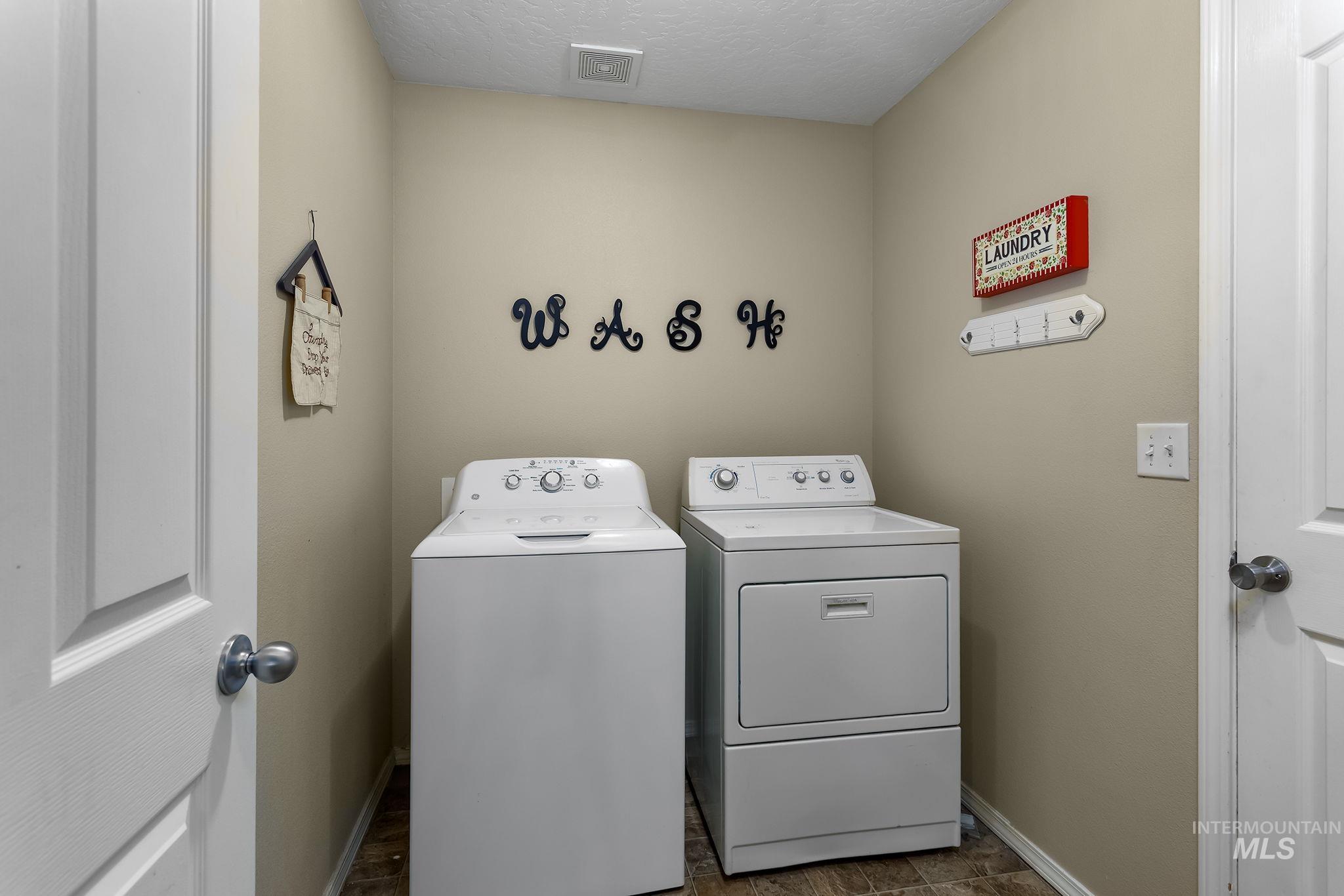 Washroom with independent washer and dryer and a textured ceiling