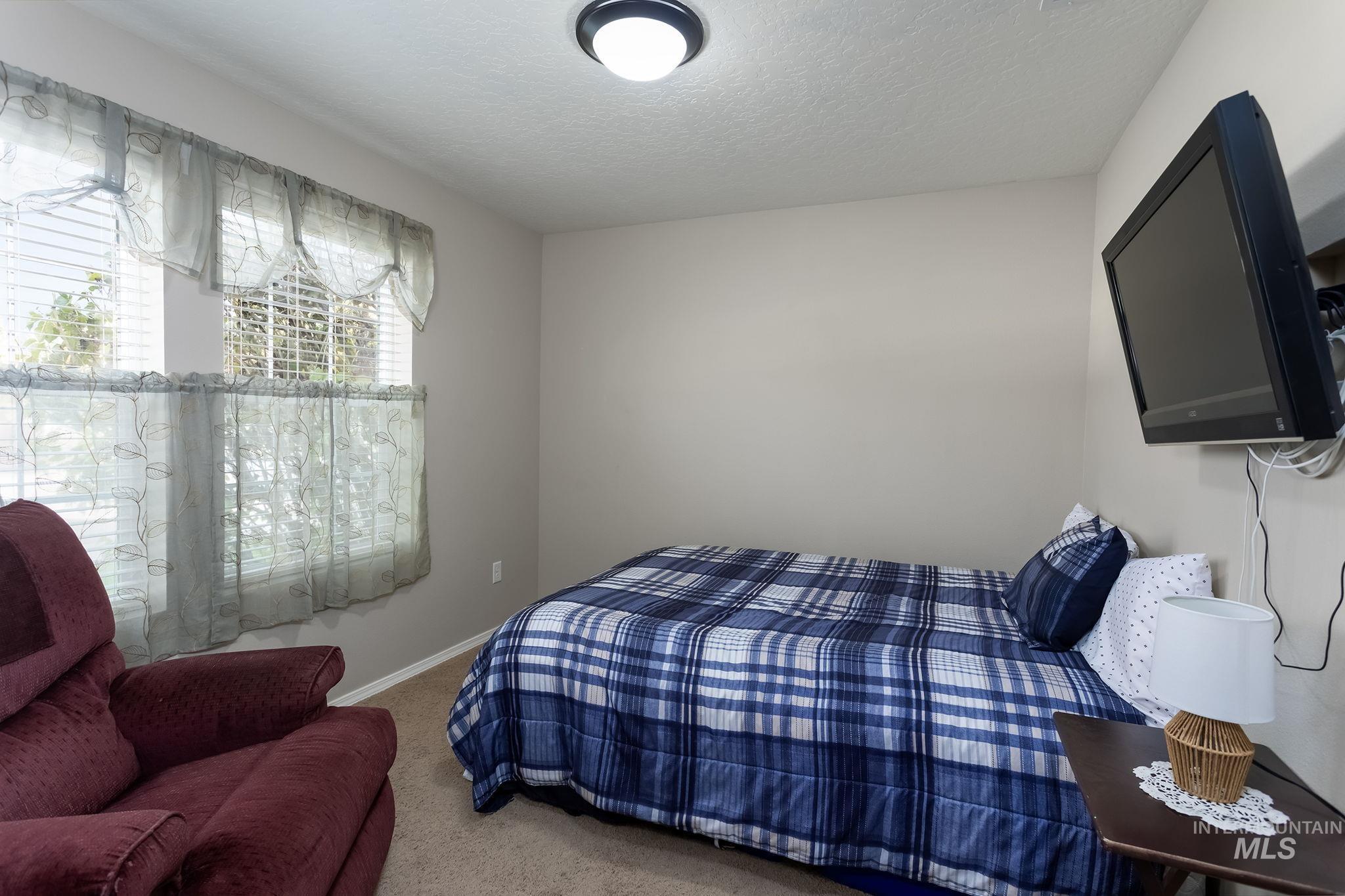 Bedroom featuring carpet and a textured ceiling