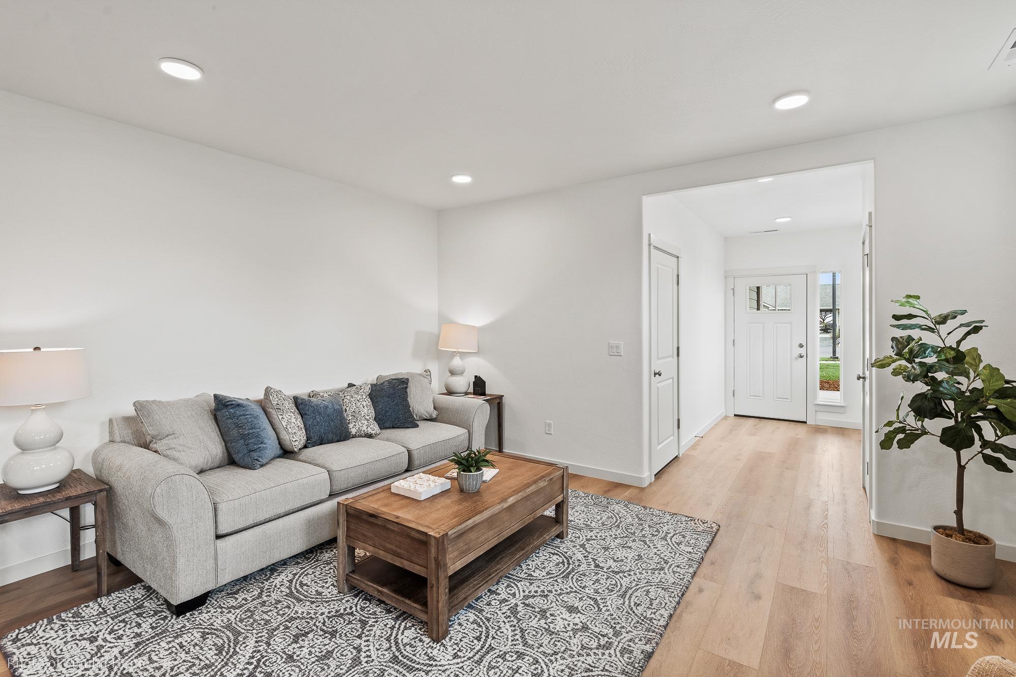 Living area with light wood-style flooring and recessed lighting