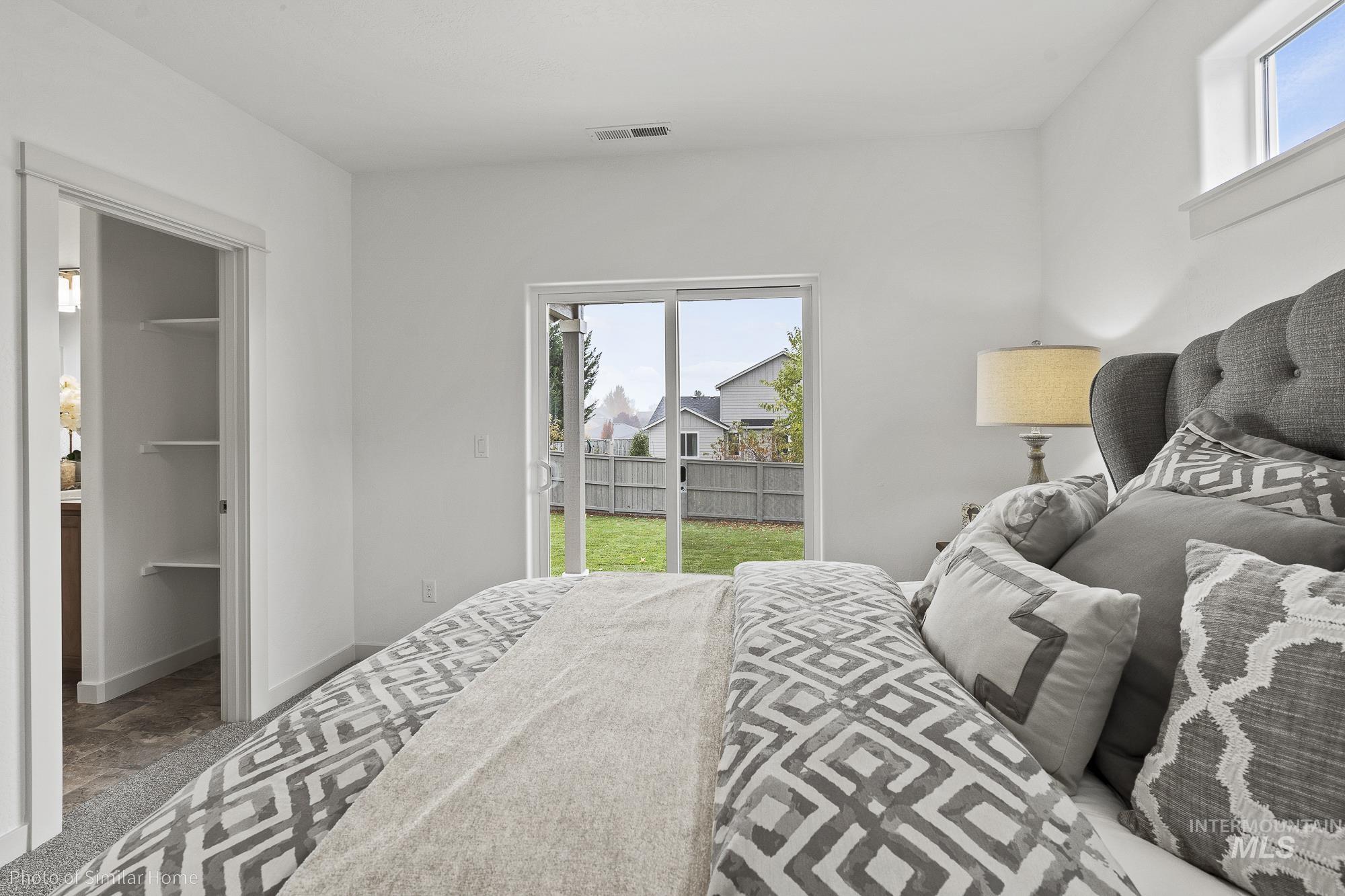 Bedroom featuring access to exterior, carpet flooring, and a spacious closet