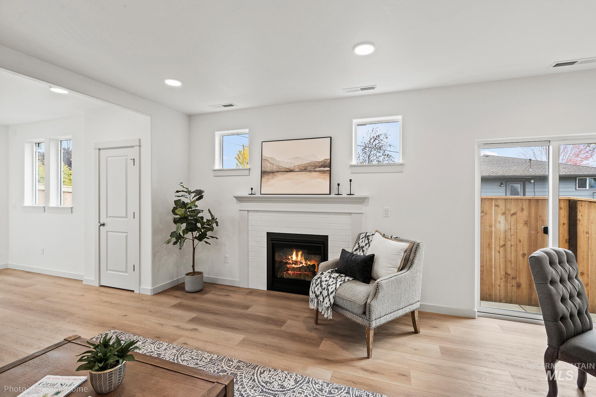Living area with a fireplace, wood finished floors, and recessed lighting