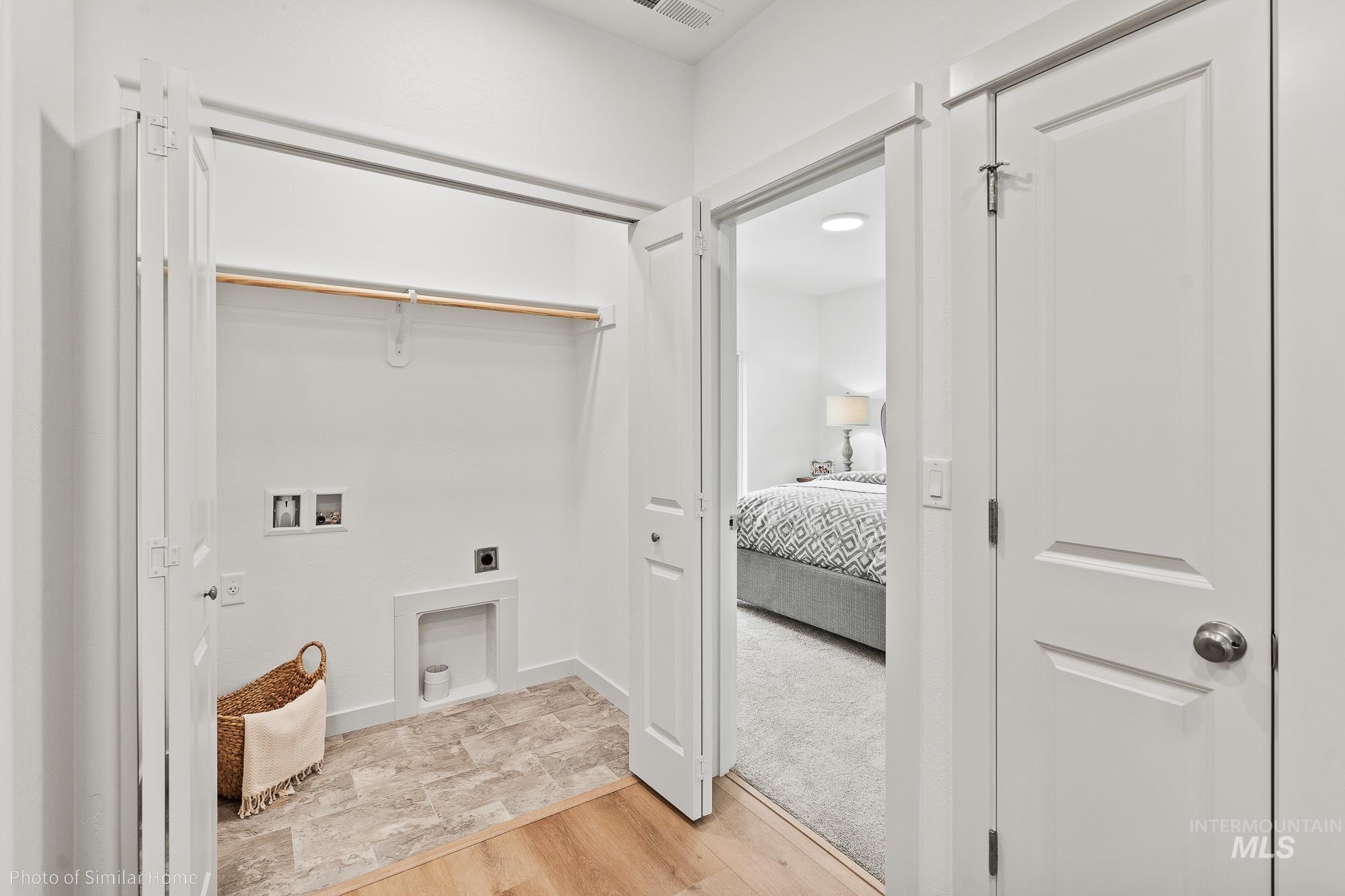 Washroom featuring electric dryer hookup, washer hookup, and light wood finished floors