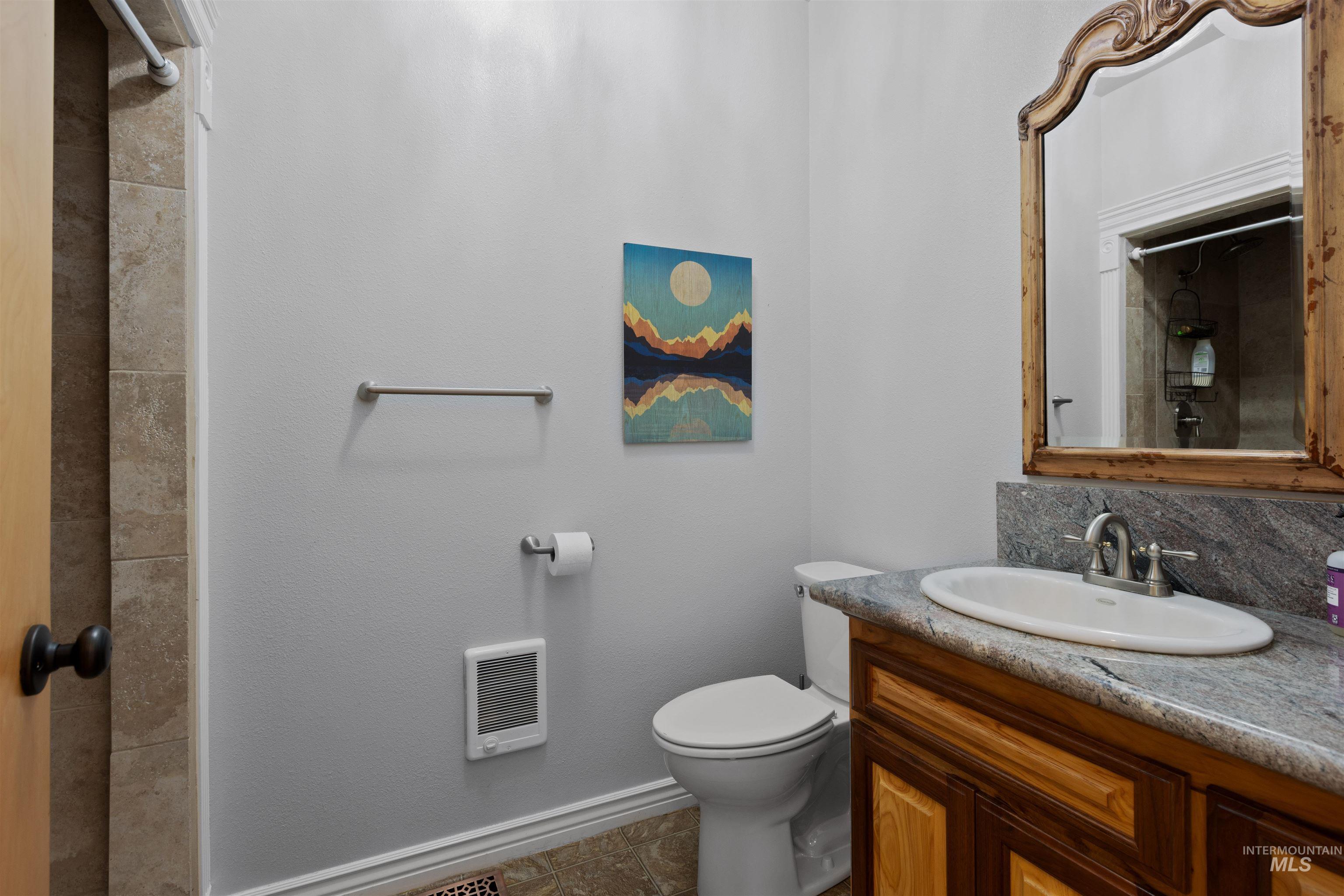 Bathroom with a shower, vanity, heating unit, and decorative backsplash