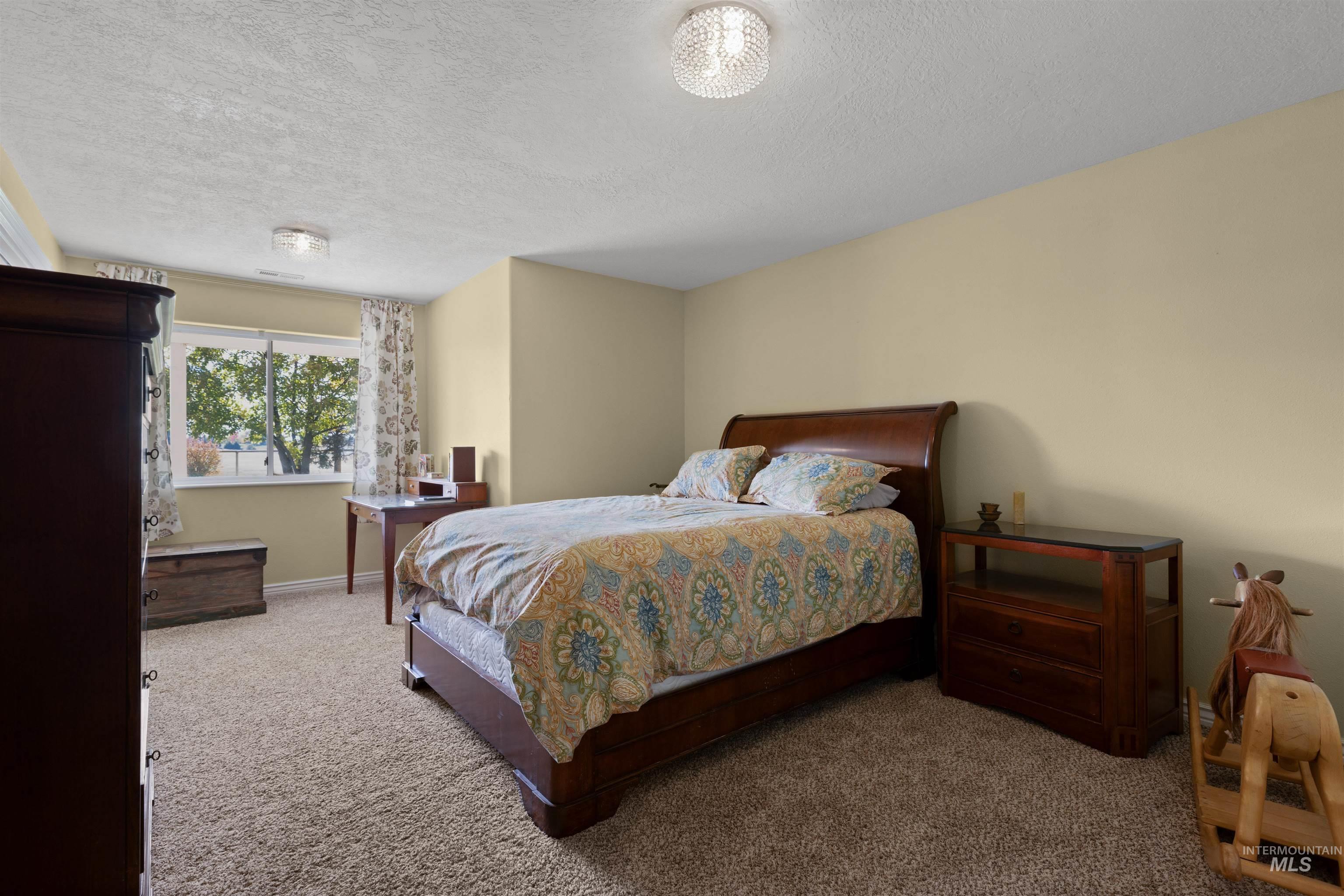 Carpeted bedroom featuring a textured ceiling
