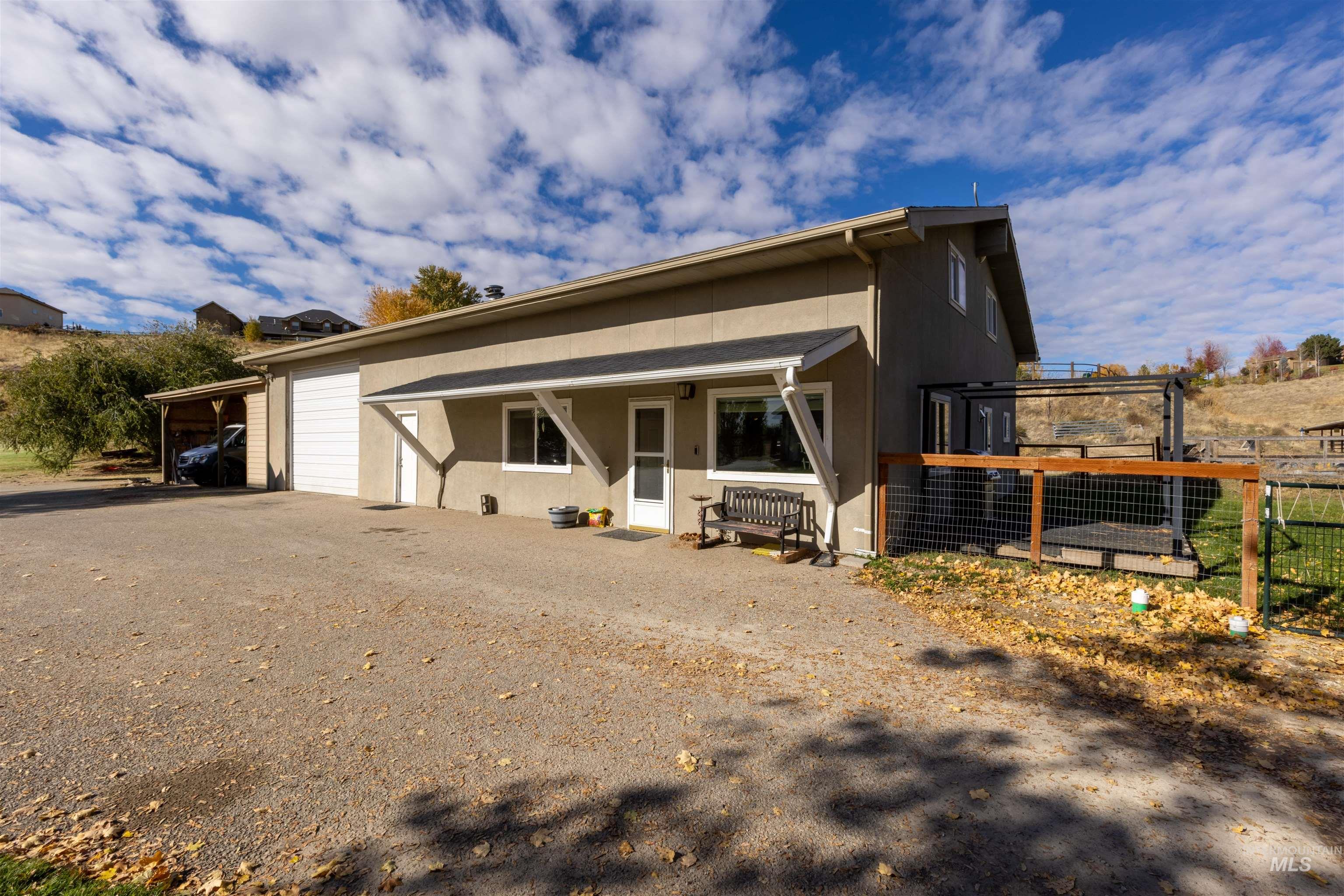 View of front facade with driveway, a garage, and stucco siding