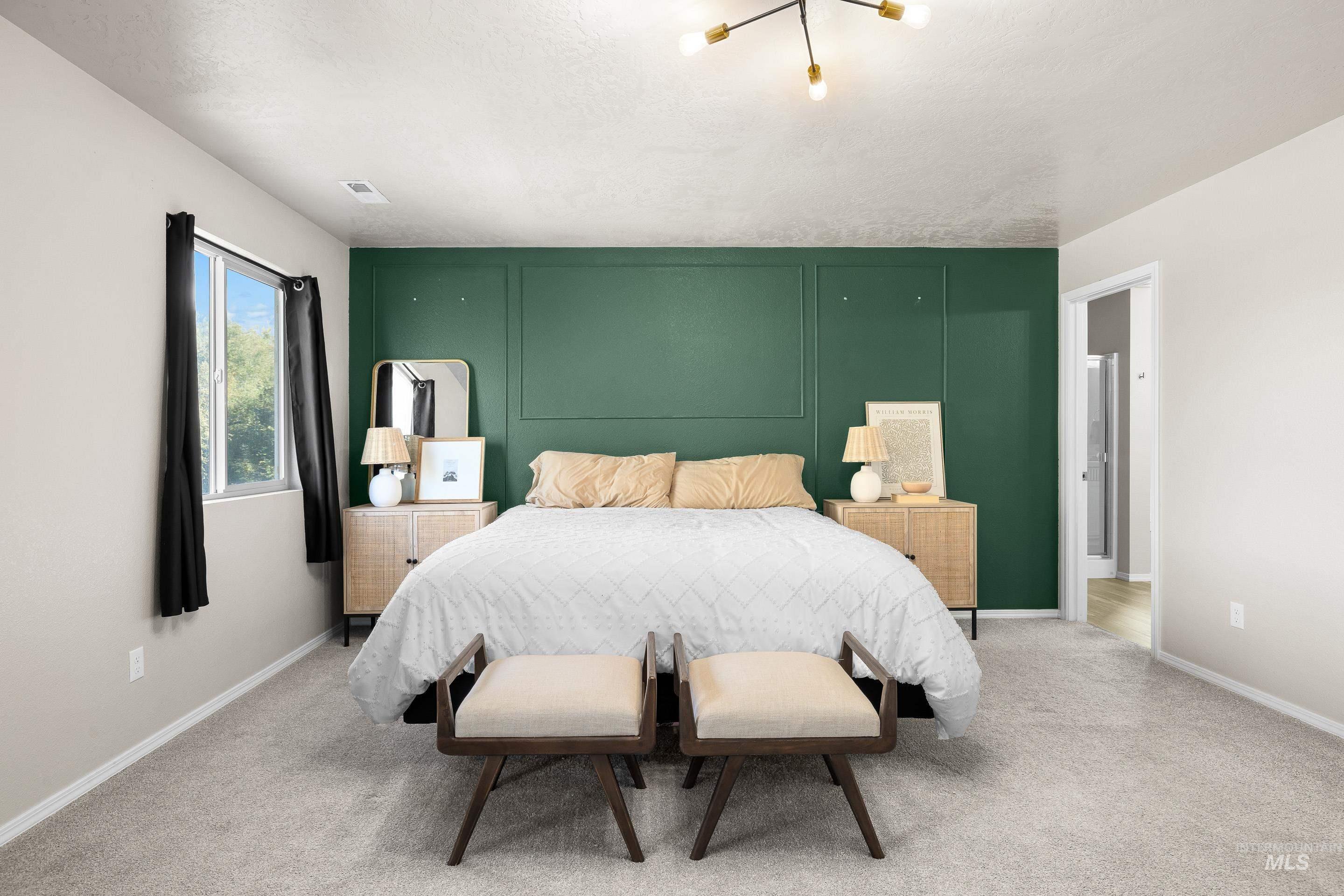 Carpeted bedroom featuring baseboards and a textured ceiling
