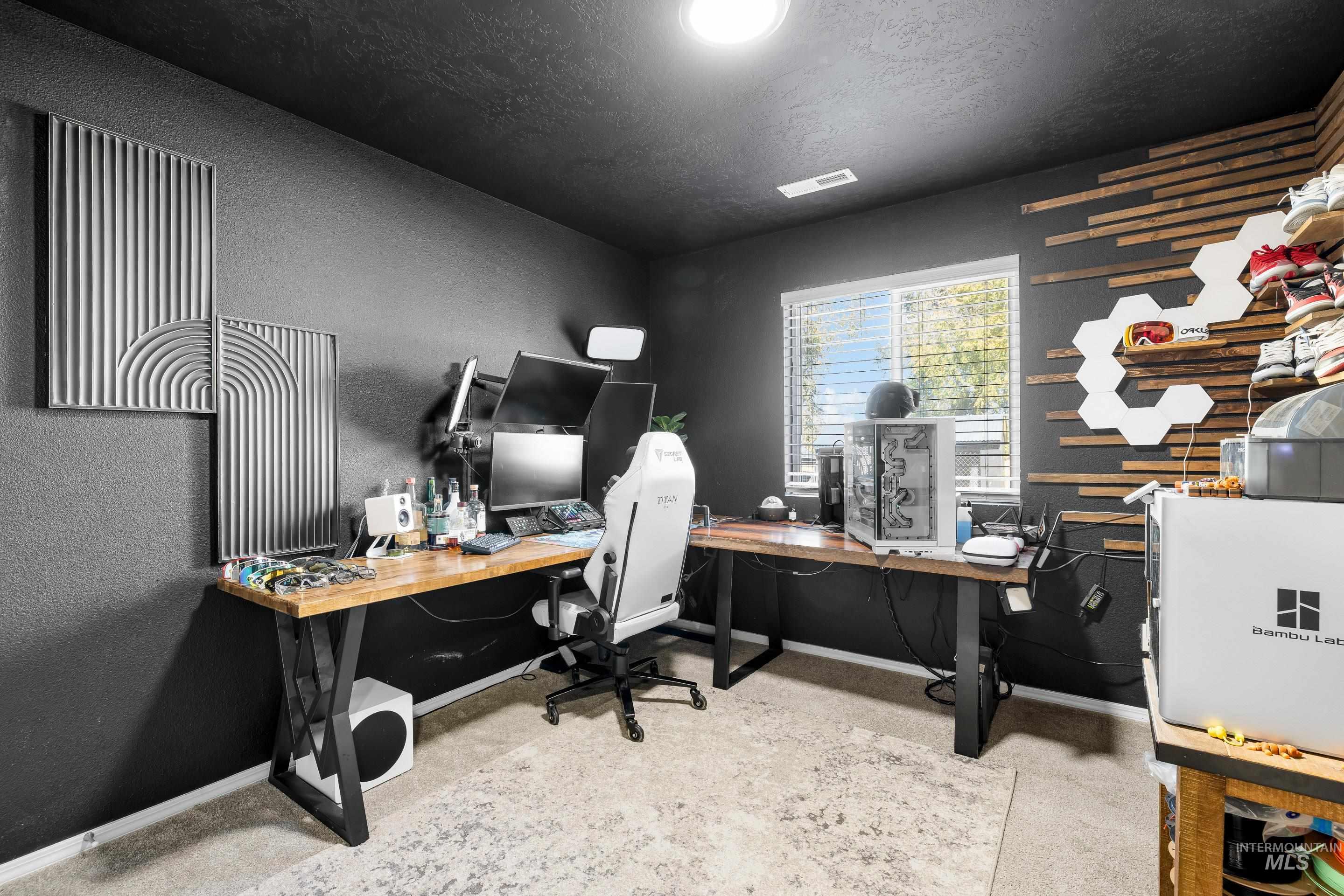 Office space featuring a textured wall and a textured ceiling