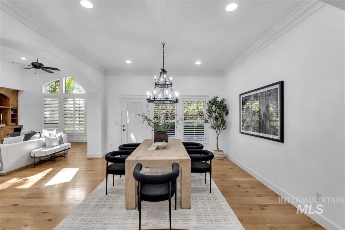 Dining area featuring crown molding, healthy amount of natural light, recessed lighting, light wood-style flooring, and a chandelier