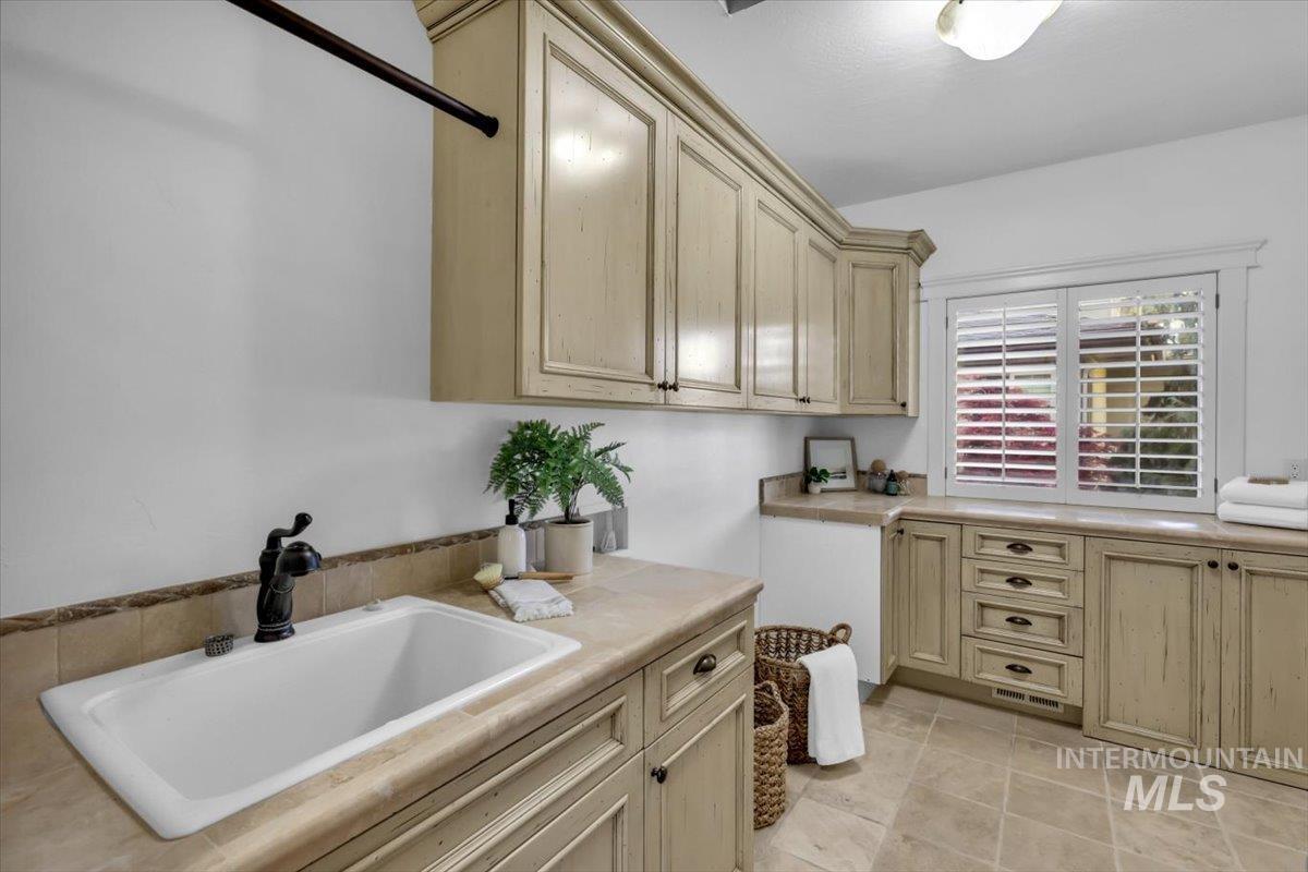 Laundry room with a sink and light tile patterned floors