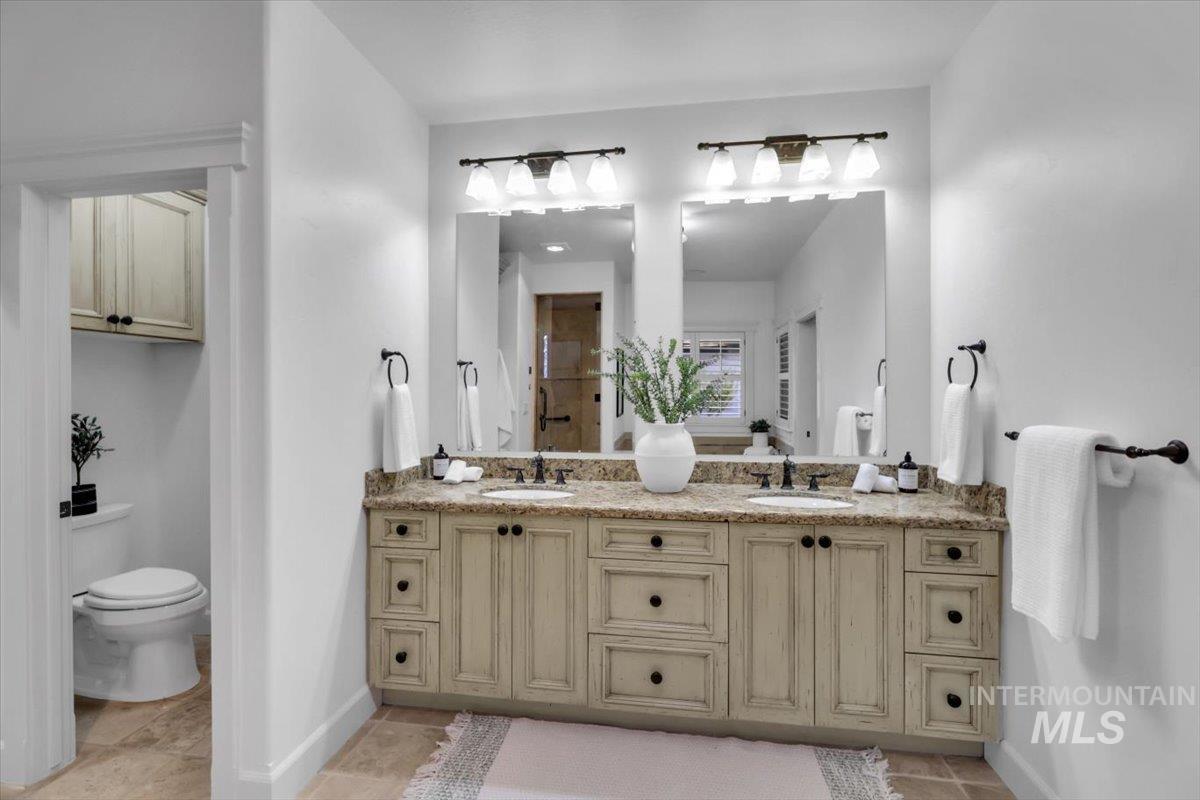 Full bathroom with double vanity and a stall shower