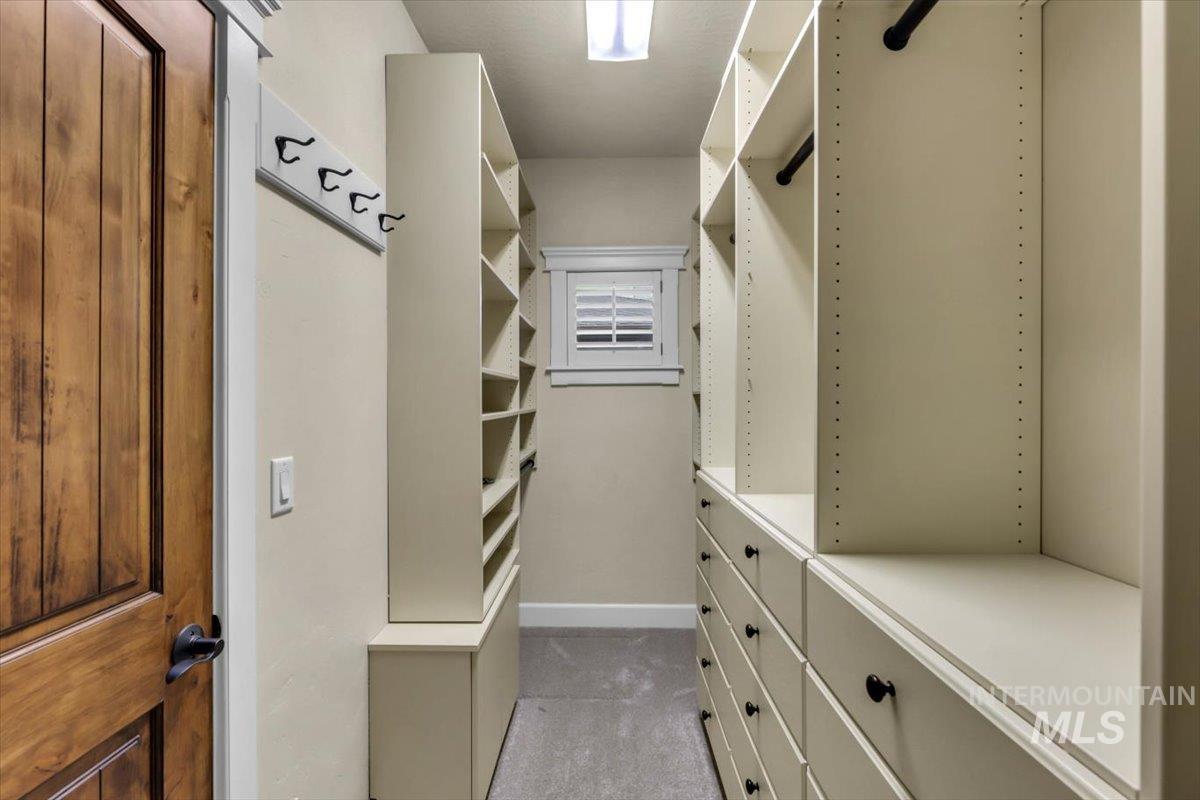 Walk in closet featuring light colored carpet