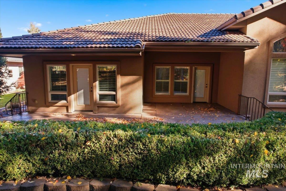 Back of house with stucco siding, a patio, and a tile roof