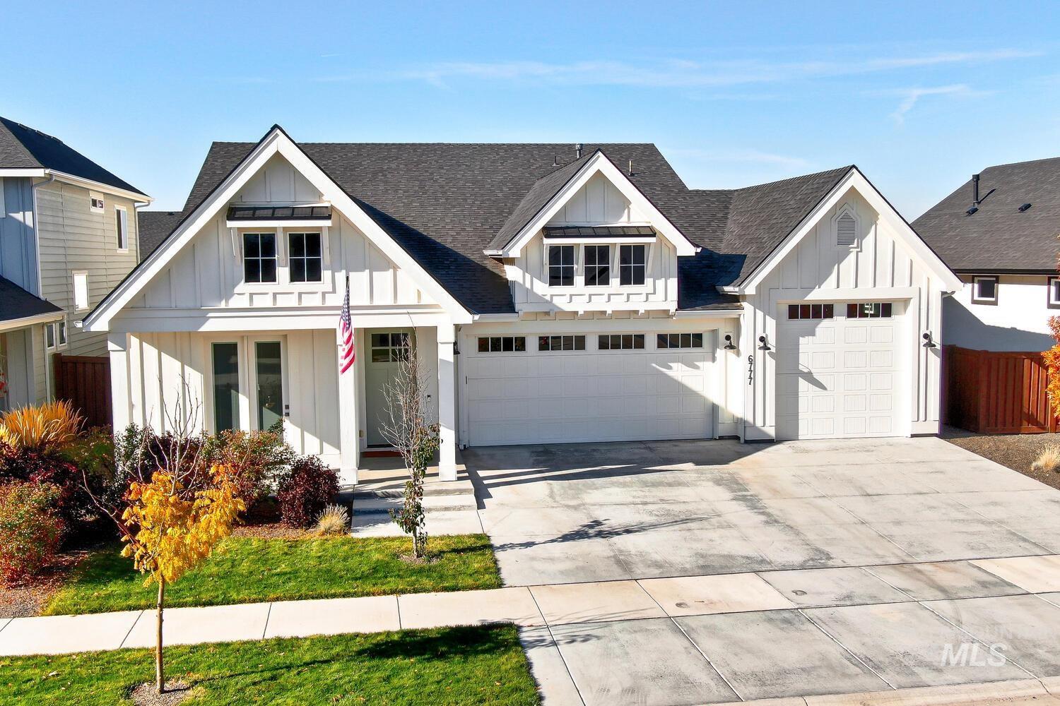Modern inspired farmhouse with board and batten siding, a shingled roof, concrete driveway, and a porch