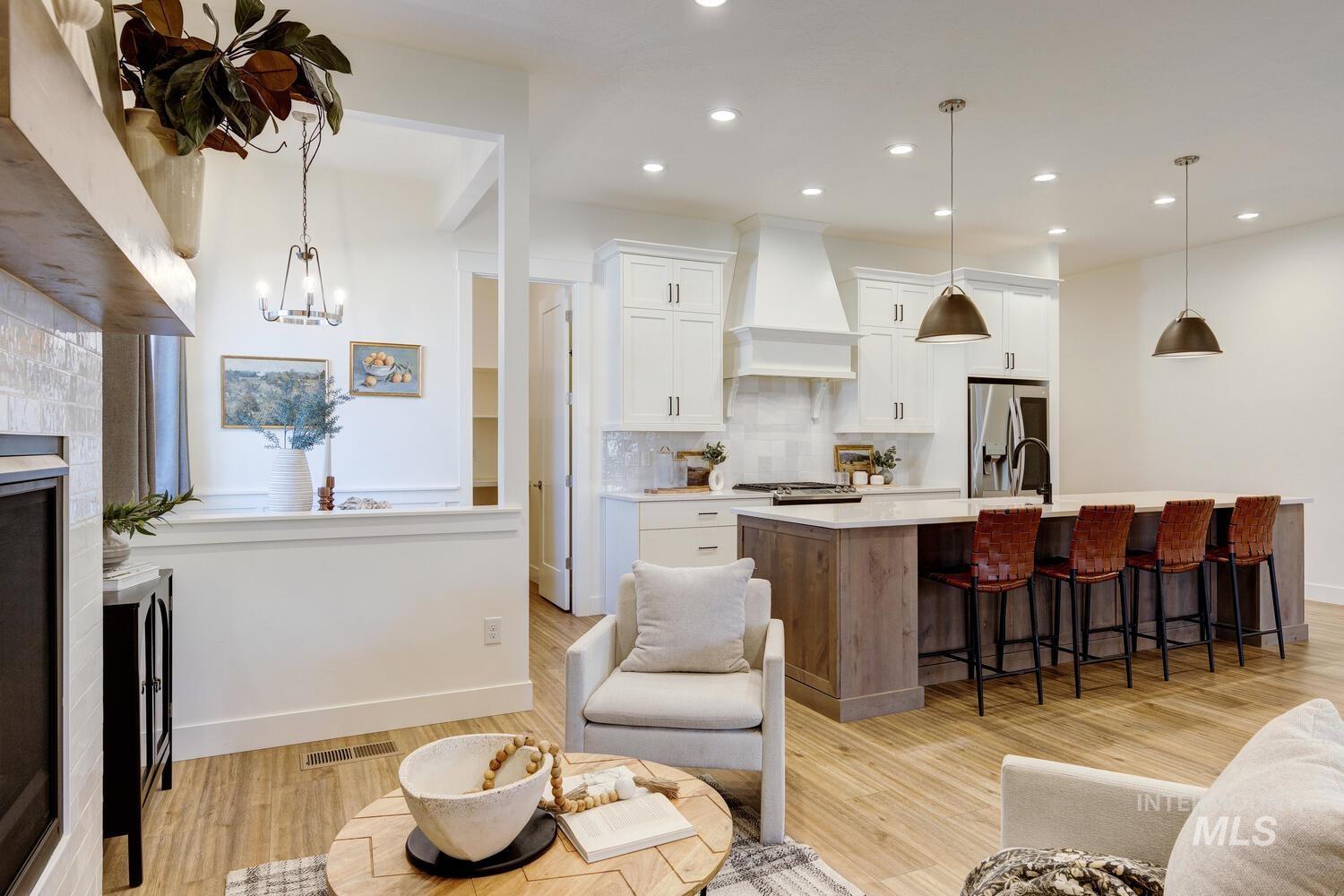 Living area featuring light wood-style floors, a fireplace, recessed lighting, and a chandelier