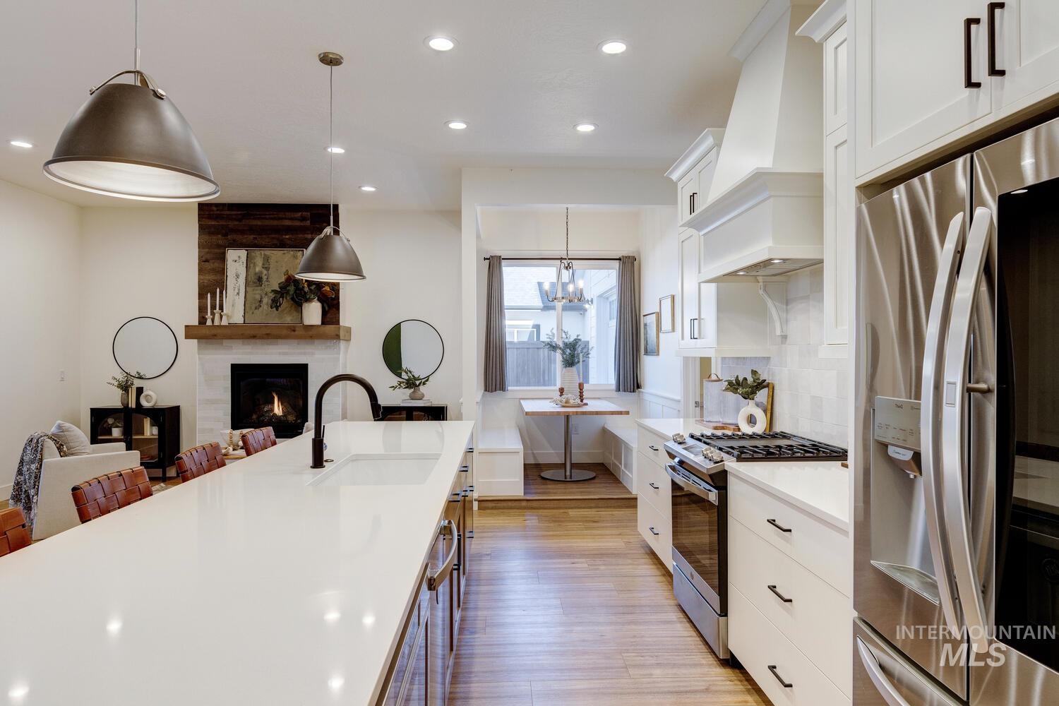 Kitchen featuring white cabinets, appliances with stainless steel finishes, hanging light fixtures, recessed lighting, and tasteful backsplash