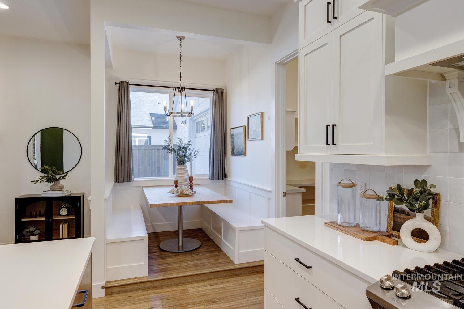 Dining room featuring light wood finished floors, a chandelier, and a wainscoted wall