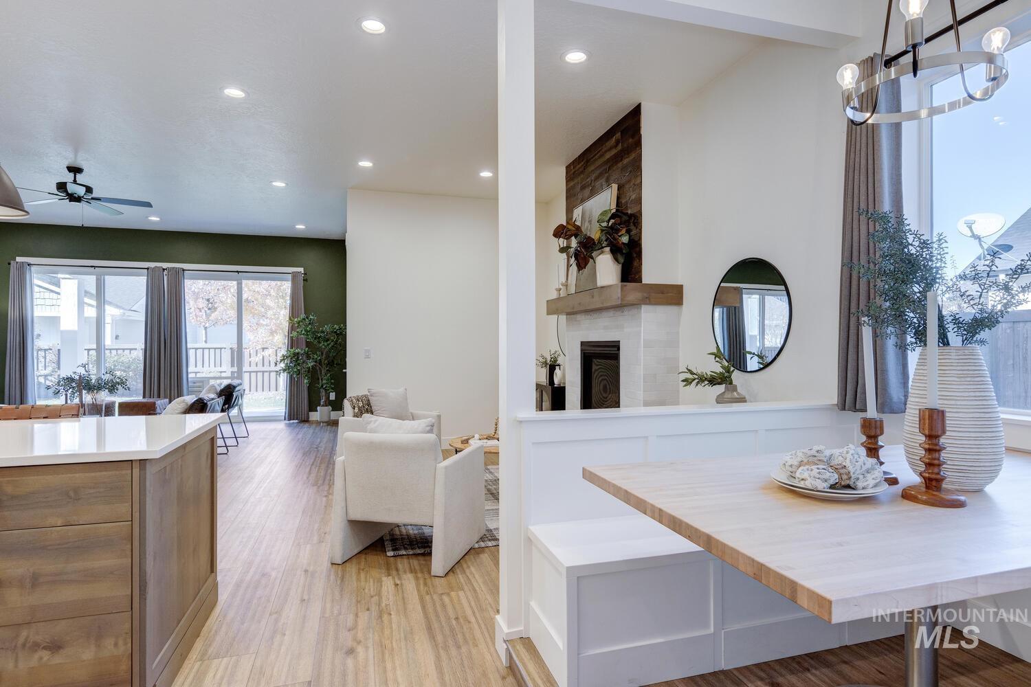 Dining space featuring light wood-style floors, ceiling fan, recessed lighting, and a fireplace