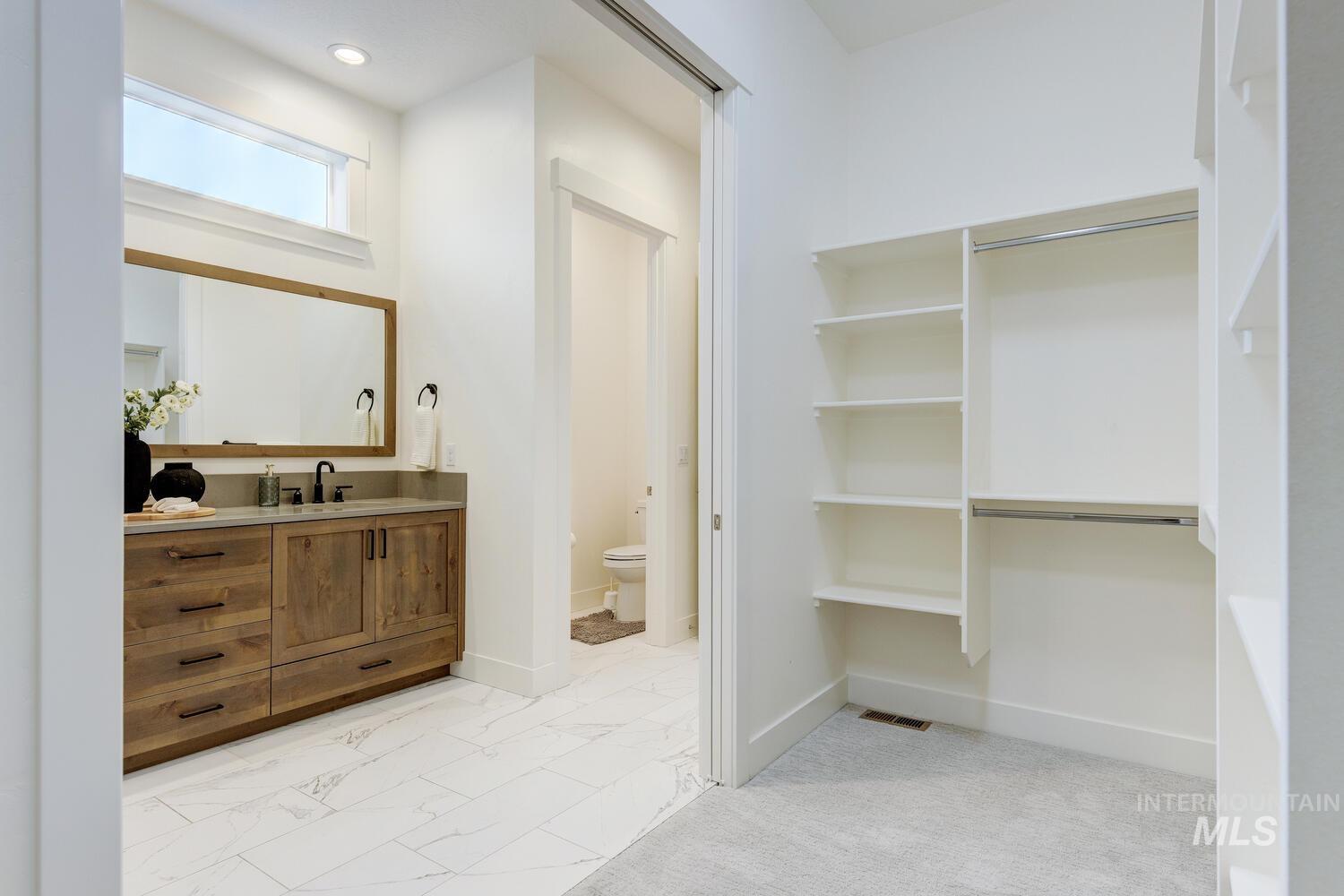 Bathroom featuring vanity and light marble finish floors