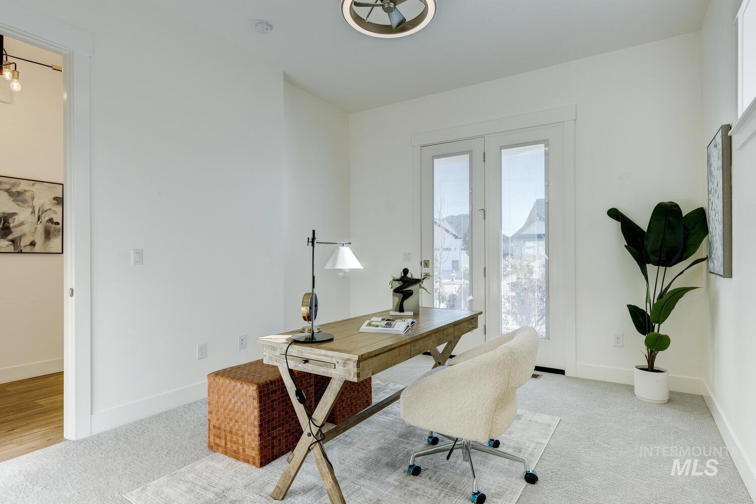 Office space with baseboards and light carpet