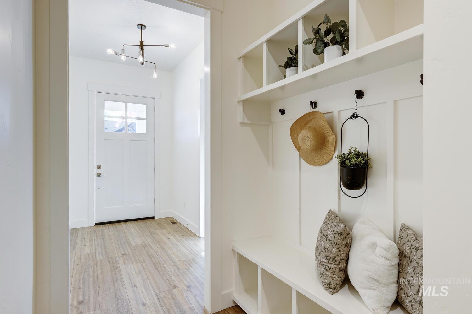 Mudroom featuring light wood-style floors and a chandelier