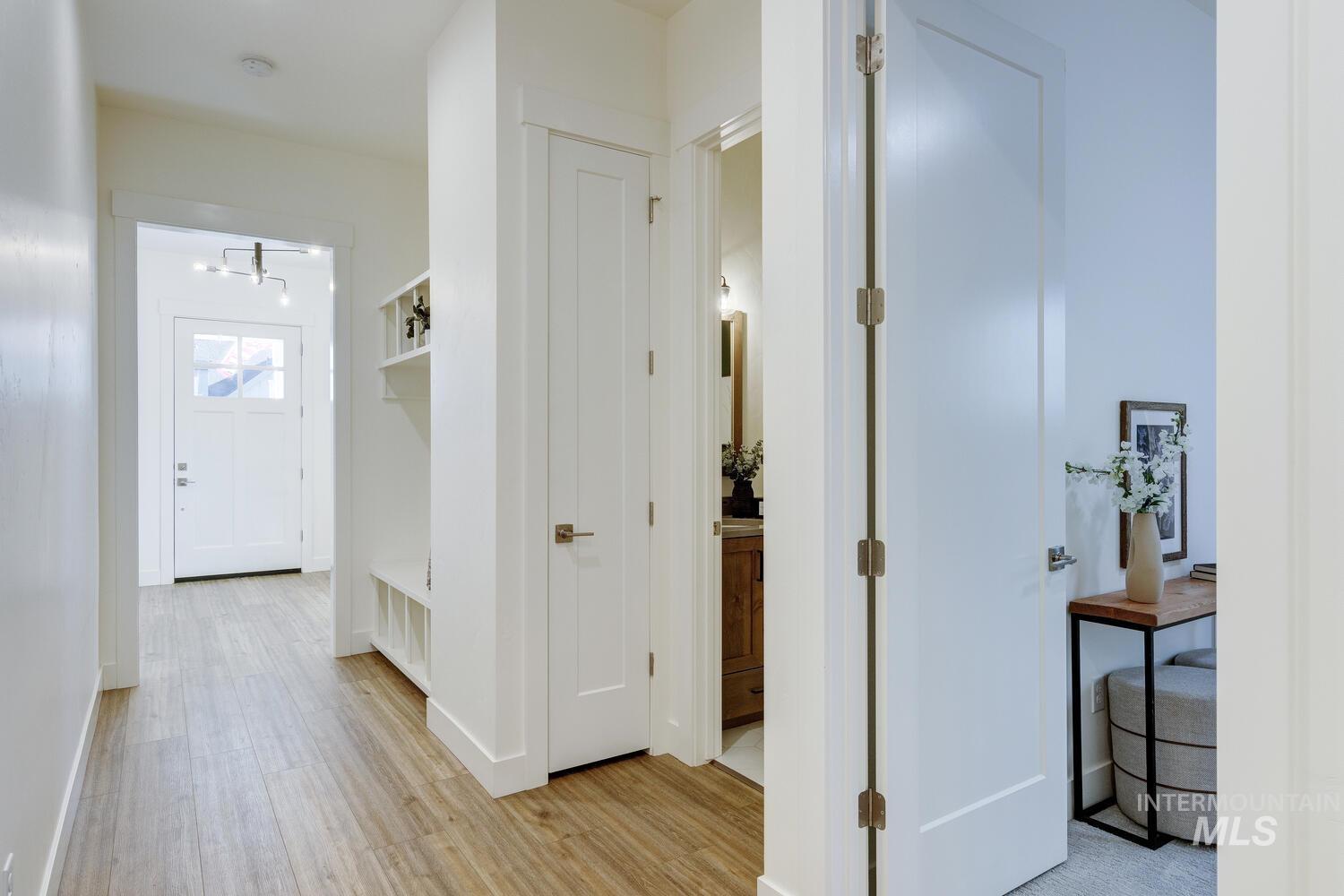 Hallway with light wood-type flooring and baseboards