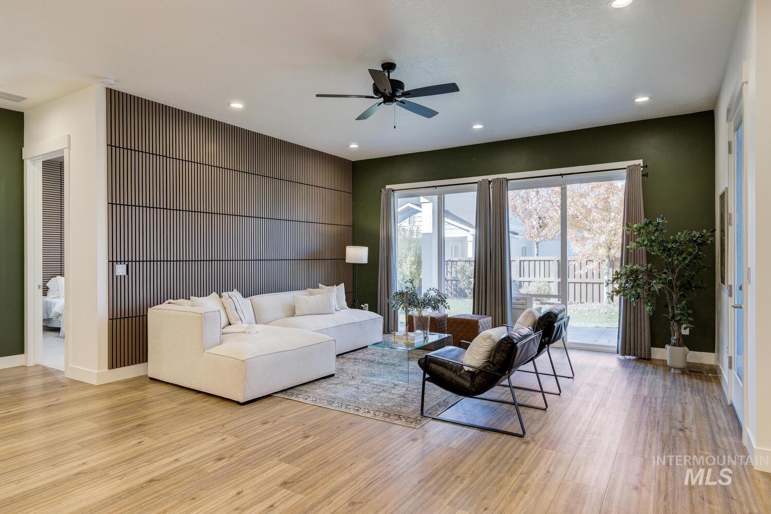 Living area with light wood-type flooring, recessed lighting, and a ceiling fan