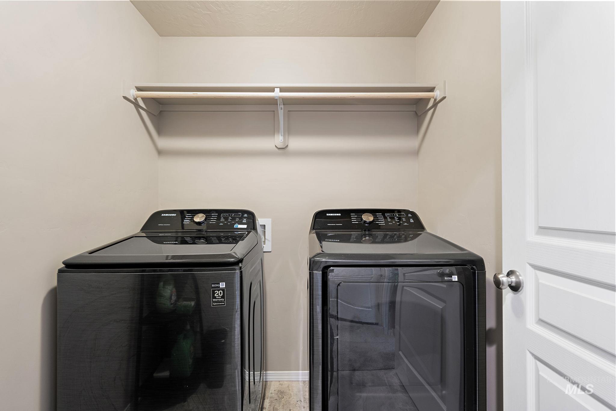 Washroom with washing machine and clothes dryer and a textured ceiling