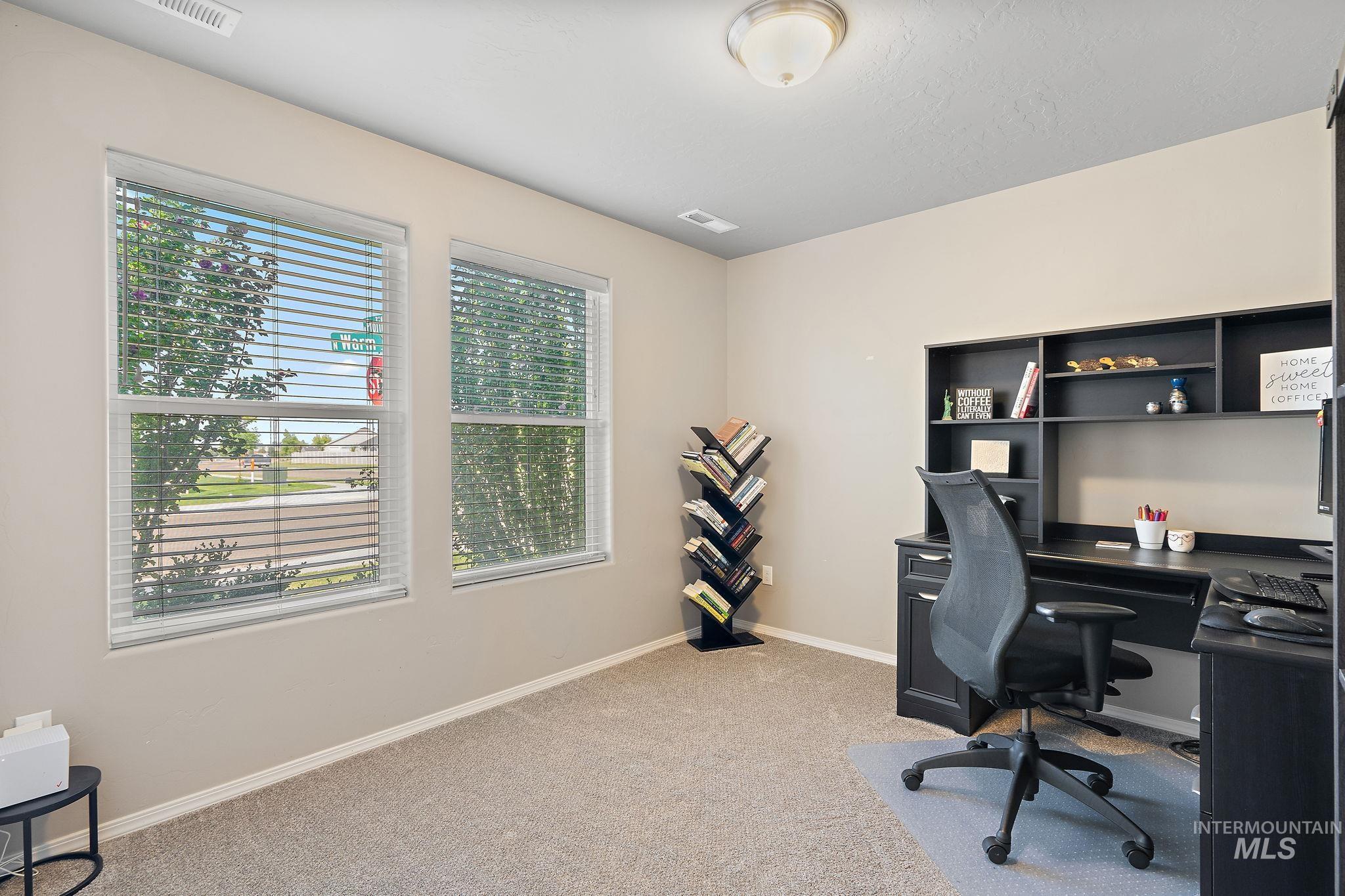 Home office featuring light carpet and baseboards