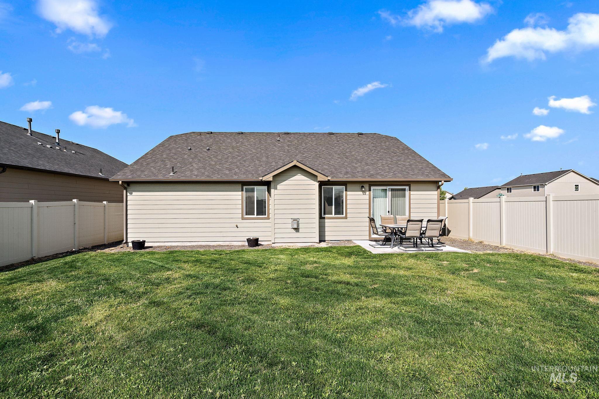 Rear view of house with a patio, a fenced backyard, and roof with shingles